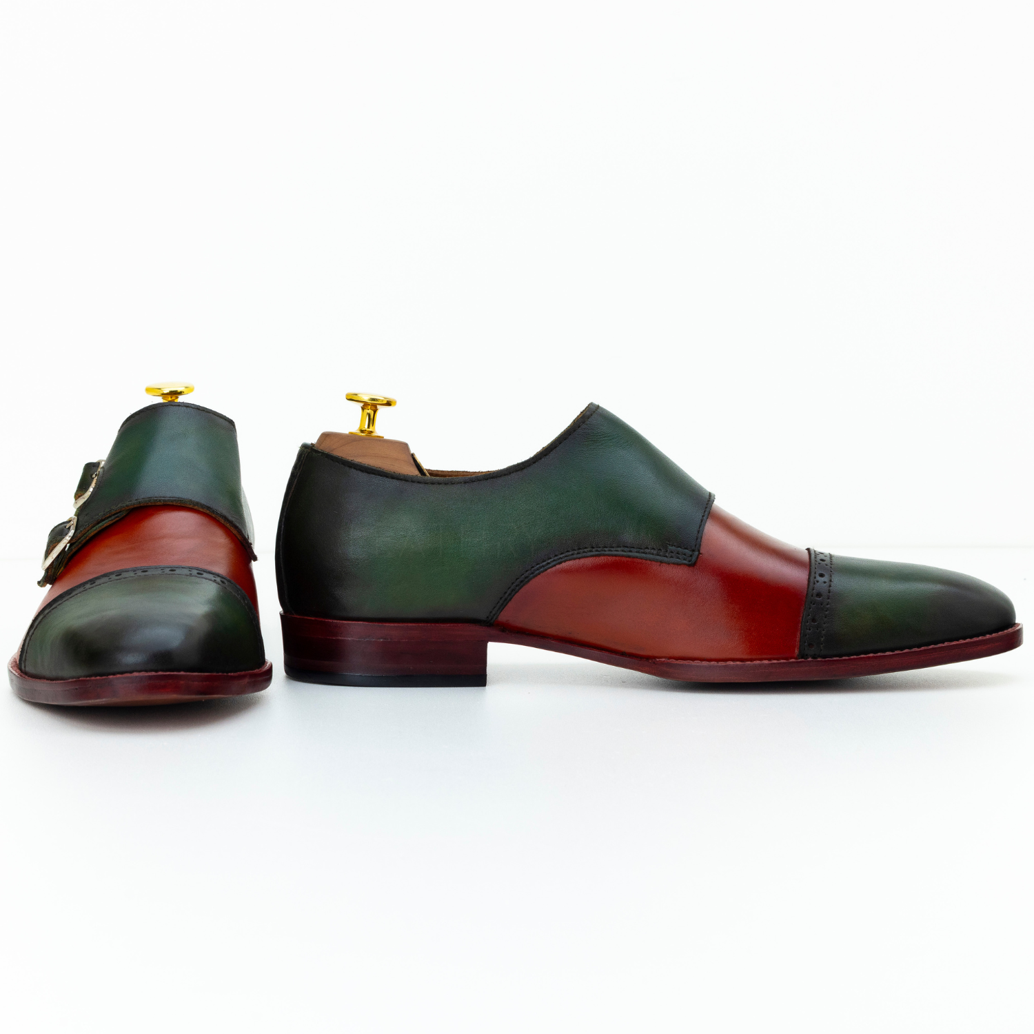 Green and red leather shoes with gold buckles on a white background