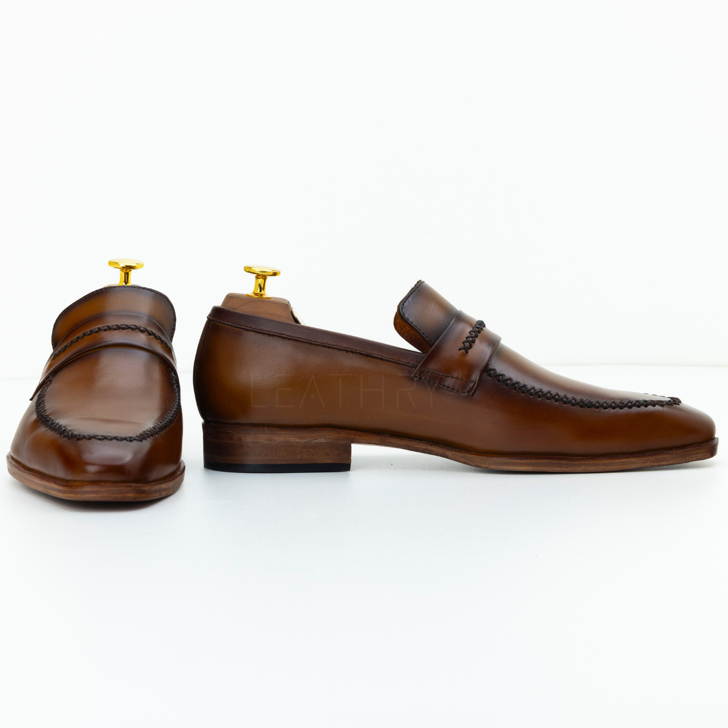 Brown leather loafers on a white background