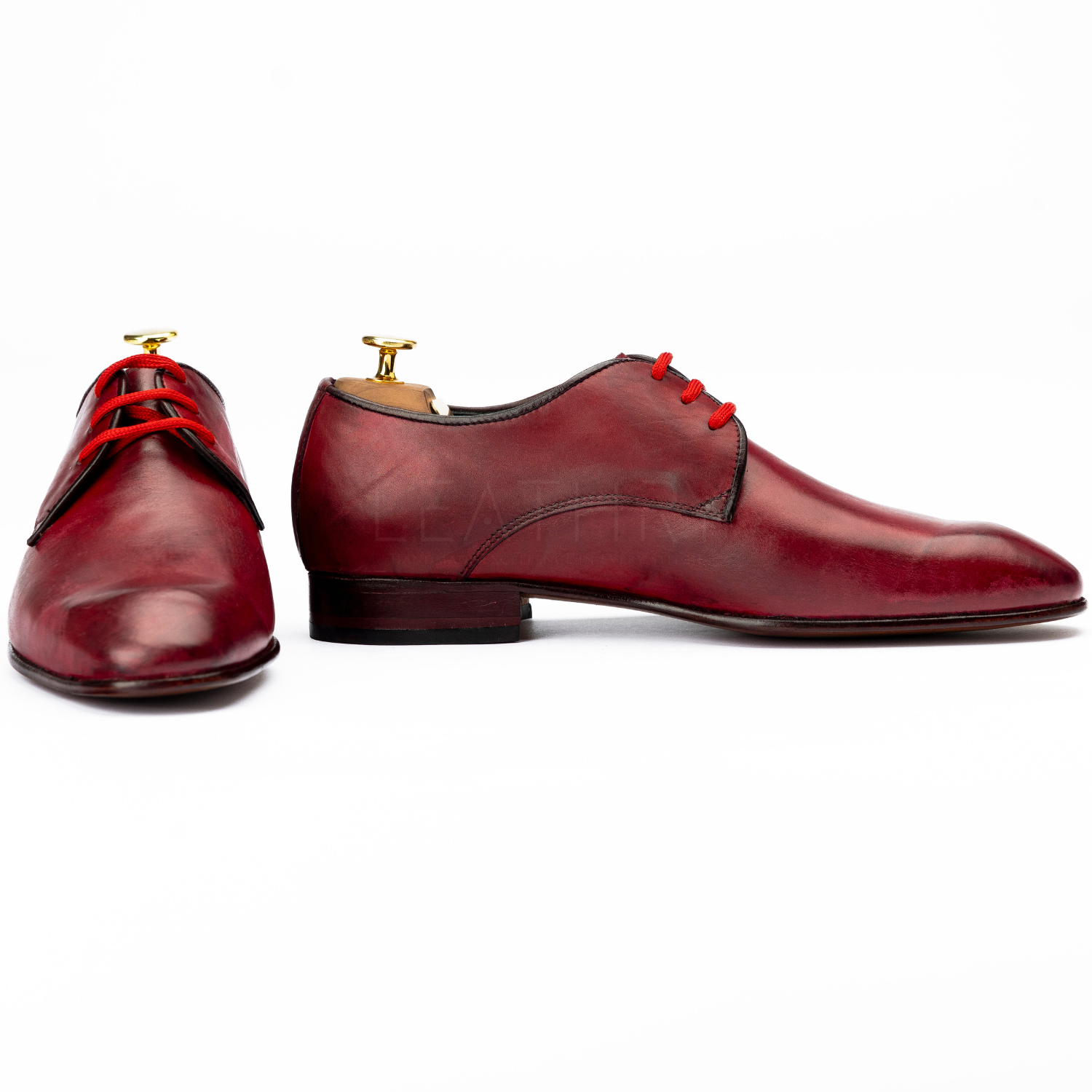 Pair of red leather dress shoes on a white background
