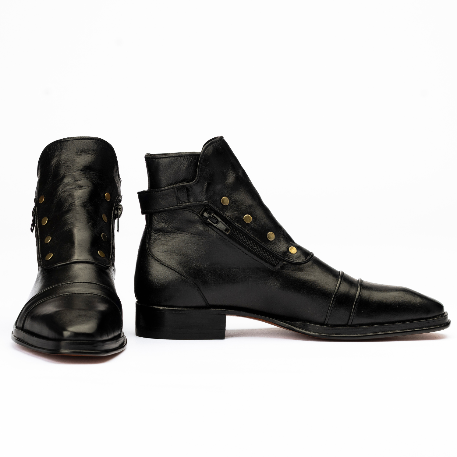Pair of black leather boots with gold buttons on a white background