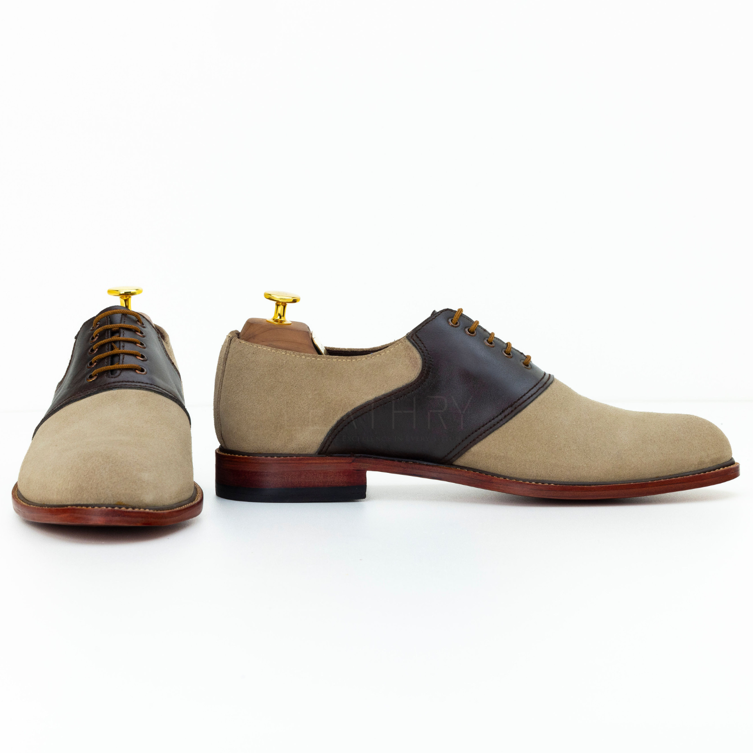 Pair of tan and black dress shoes on a white background