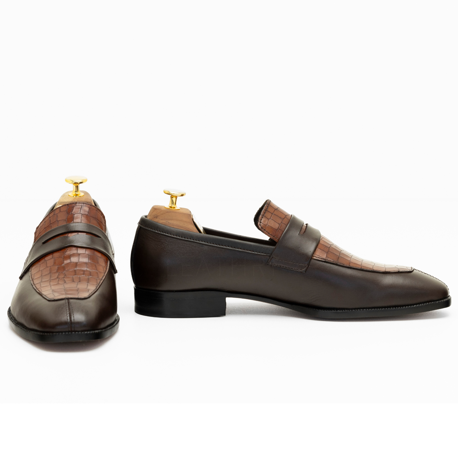 Pair of brown leather loafers on a white background