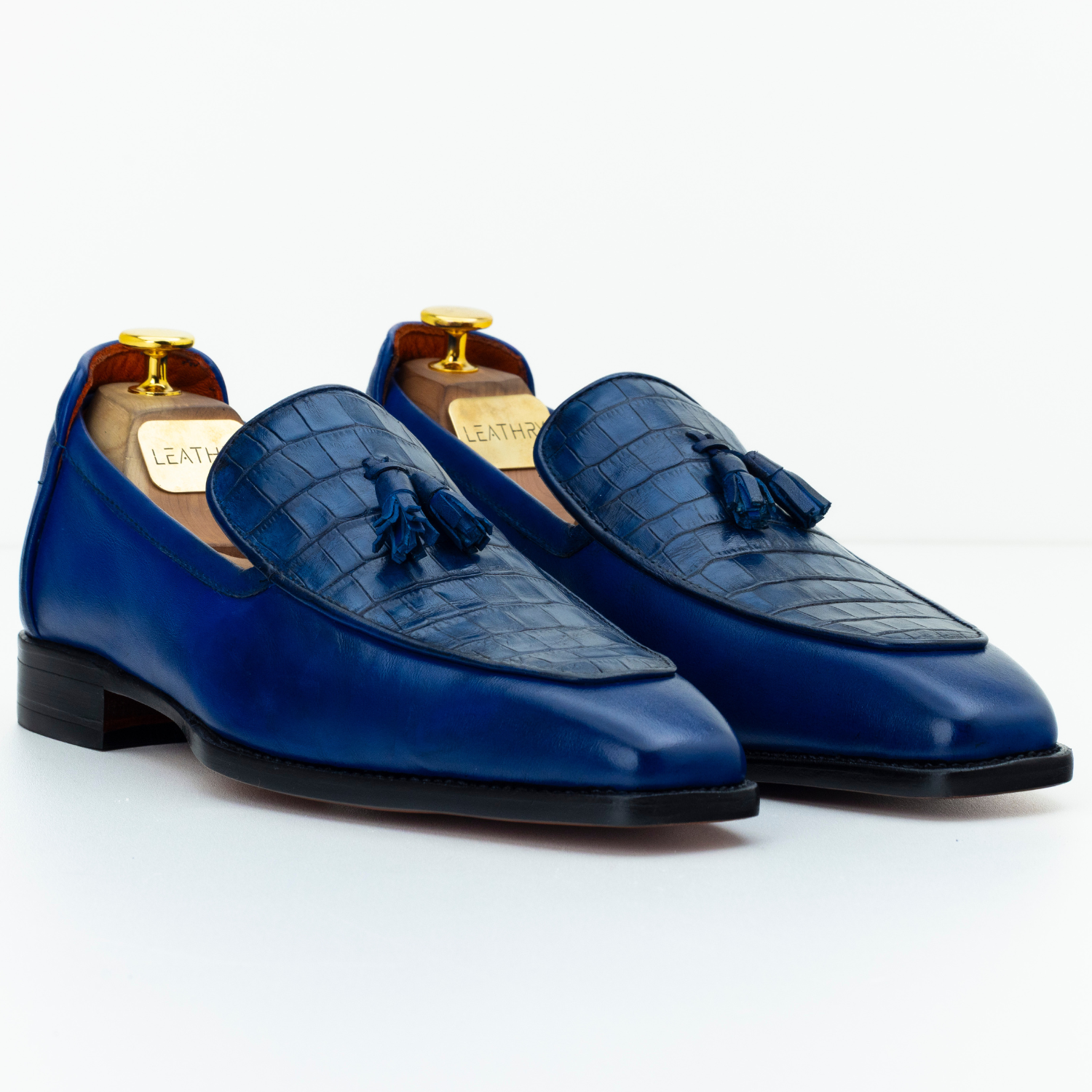 Pair of blue leather loafers with tassels on a white background