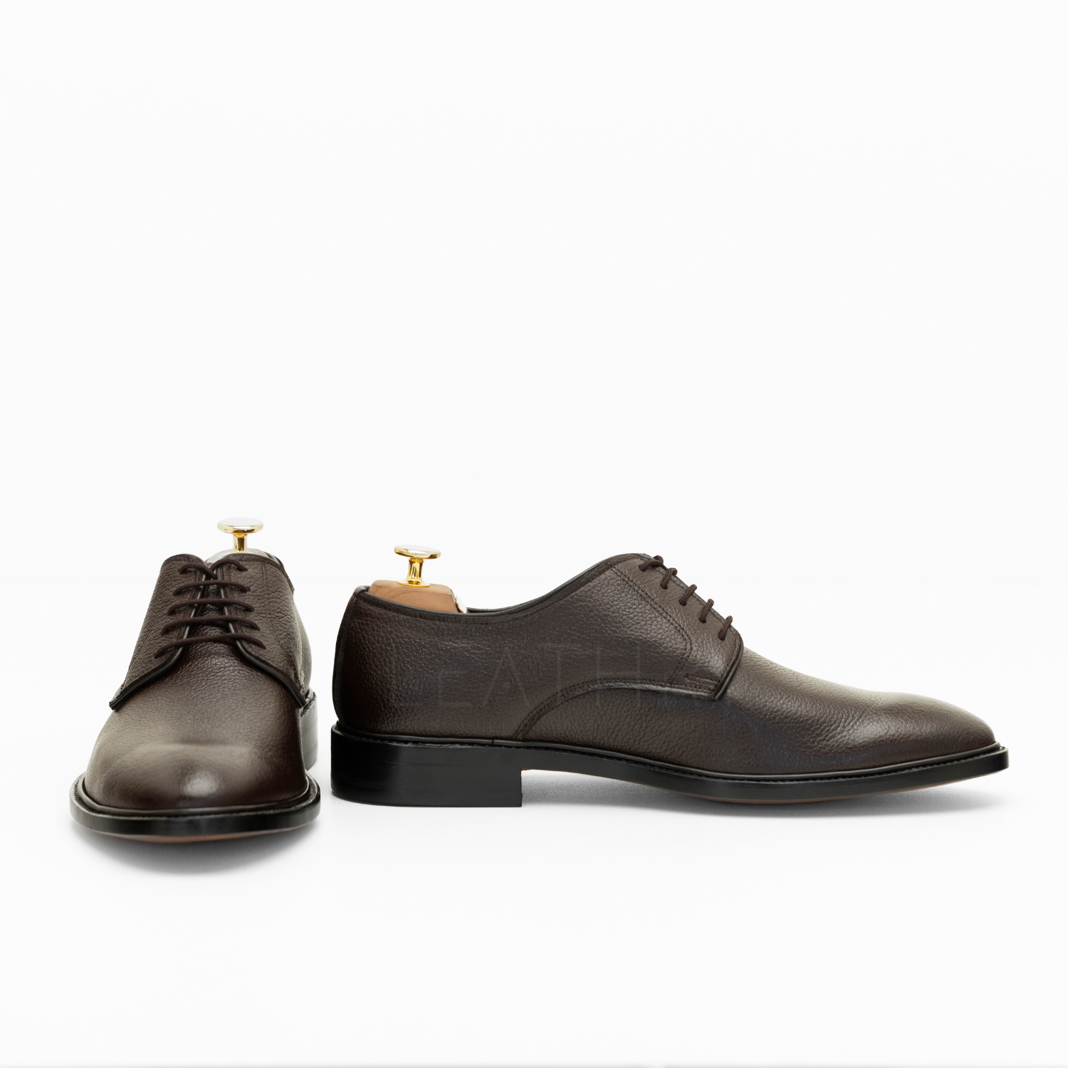 Pair of brown leather dress shoes on a white background