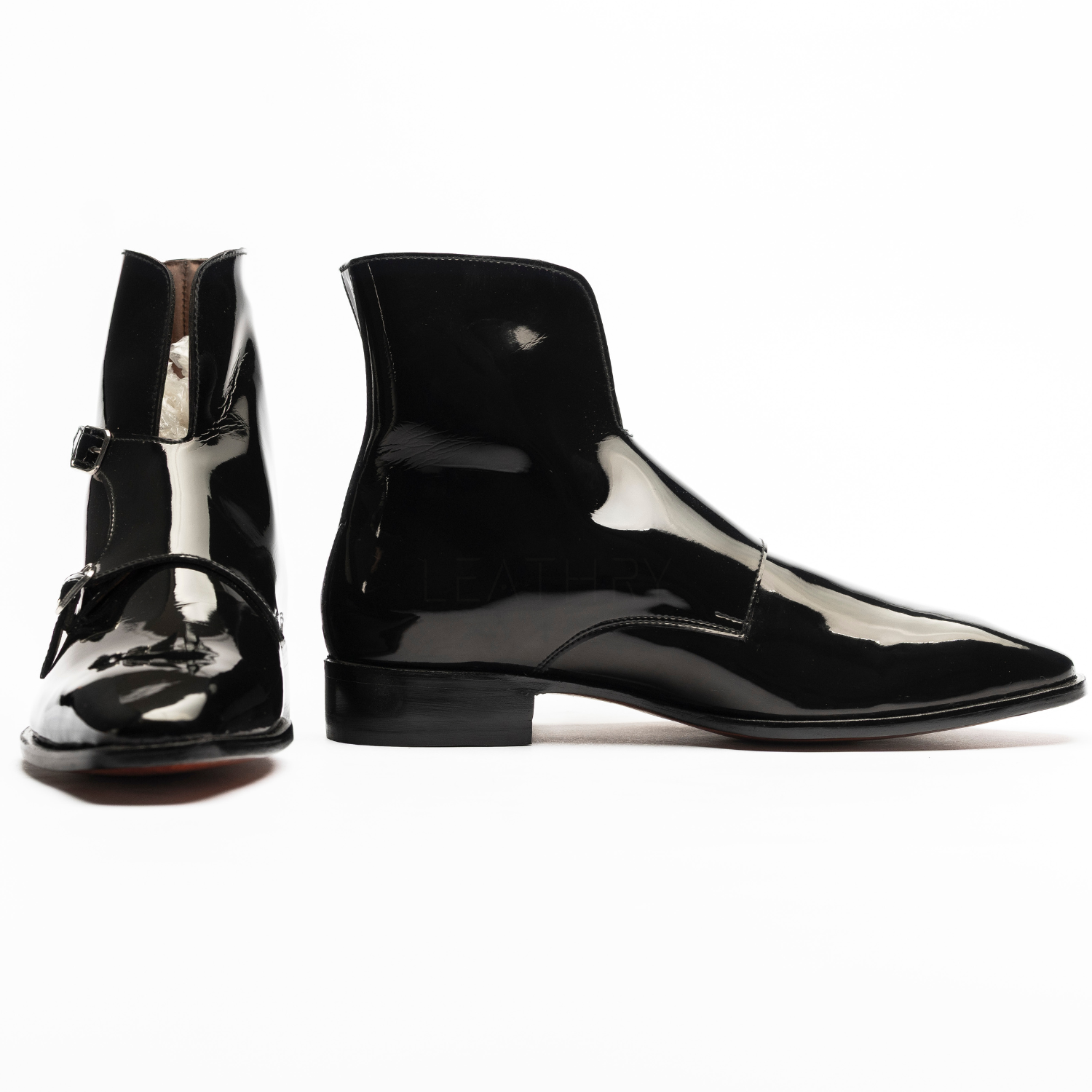 Black patent leather boots on a white background