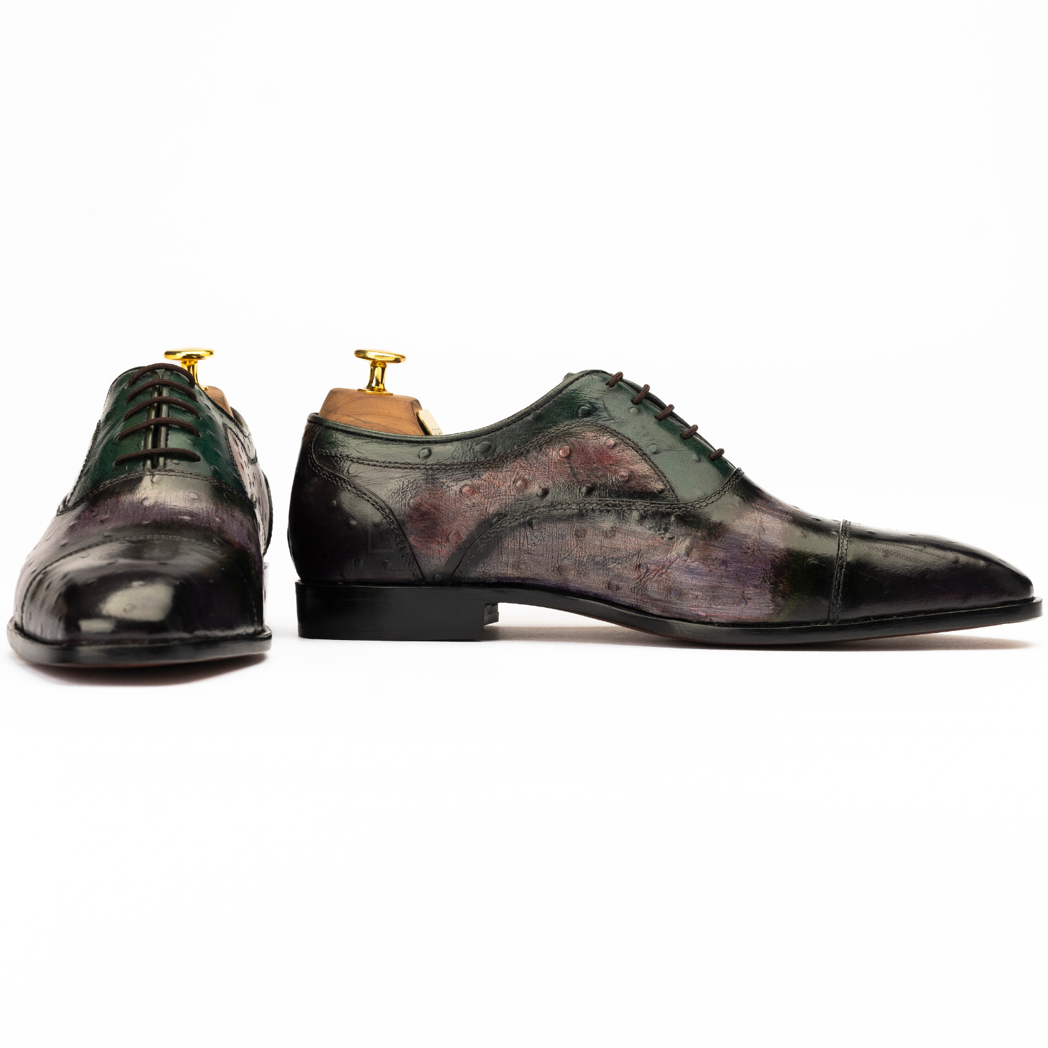 Pair of black and green dress shoes on a white background