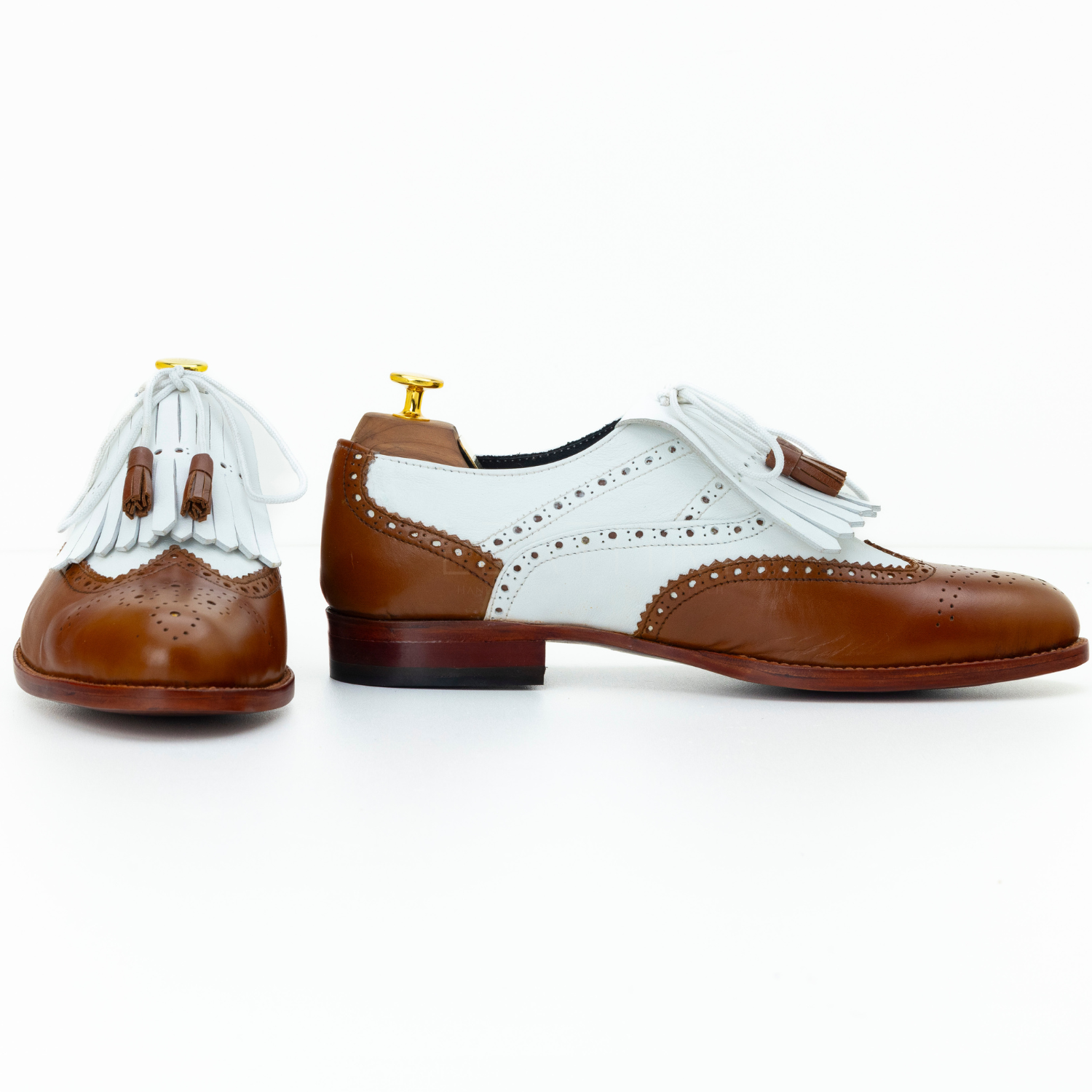 Brown and white shoes with decorative elements on a white background