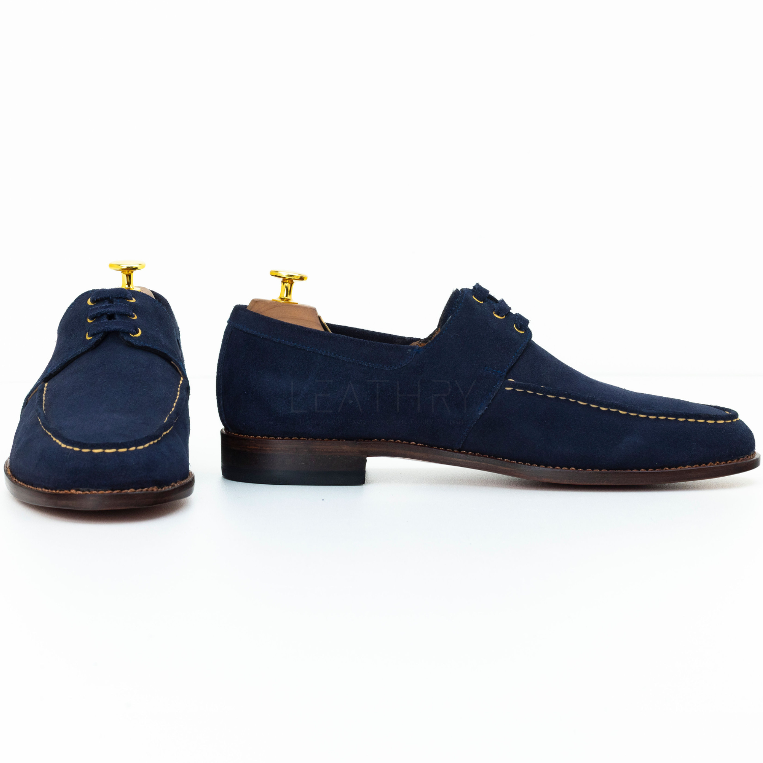 Pair of navy blue suede shoes on a white background