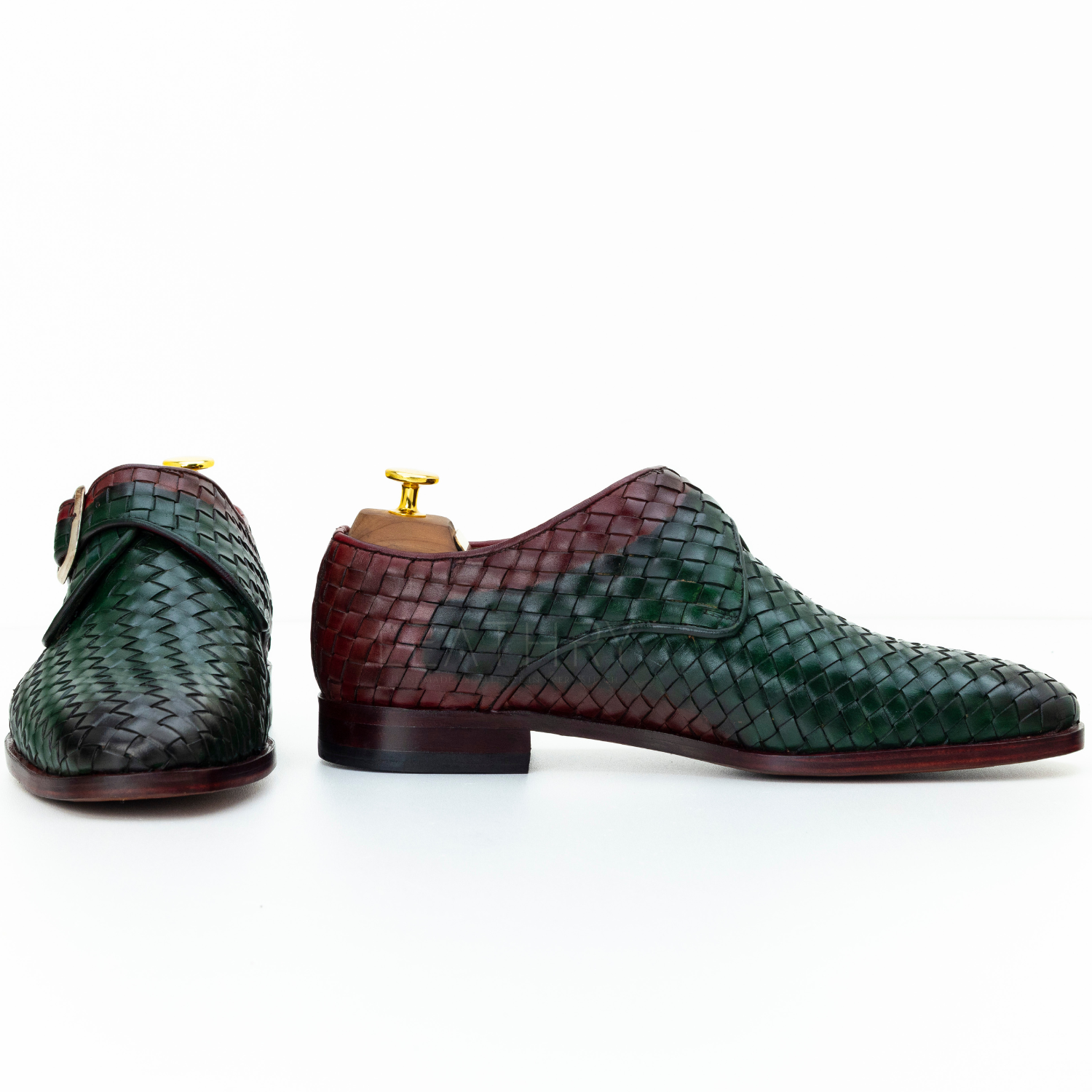 Pair of green and brown woven leather shoes on a white background