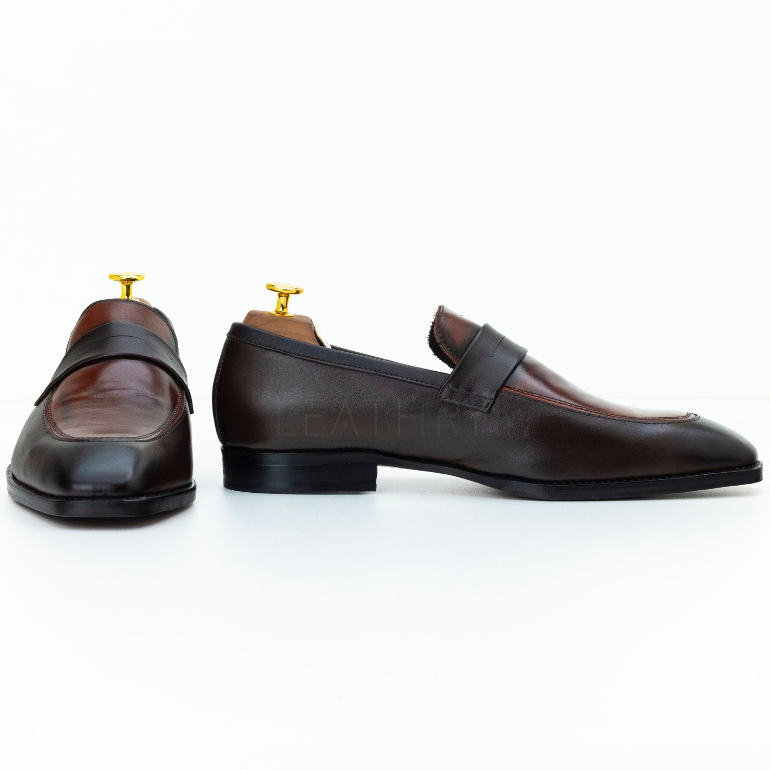 Pair of brown leather loafers on a white background