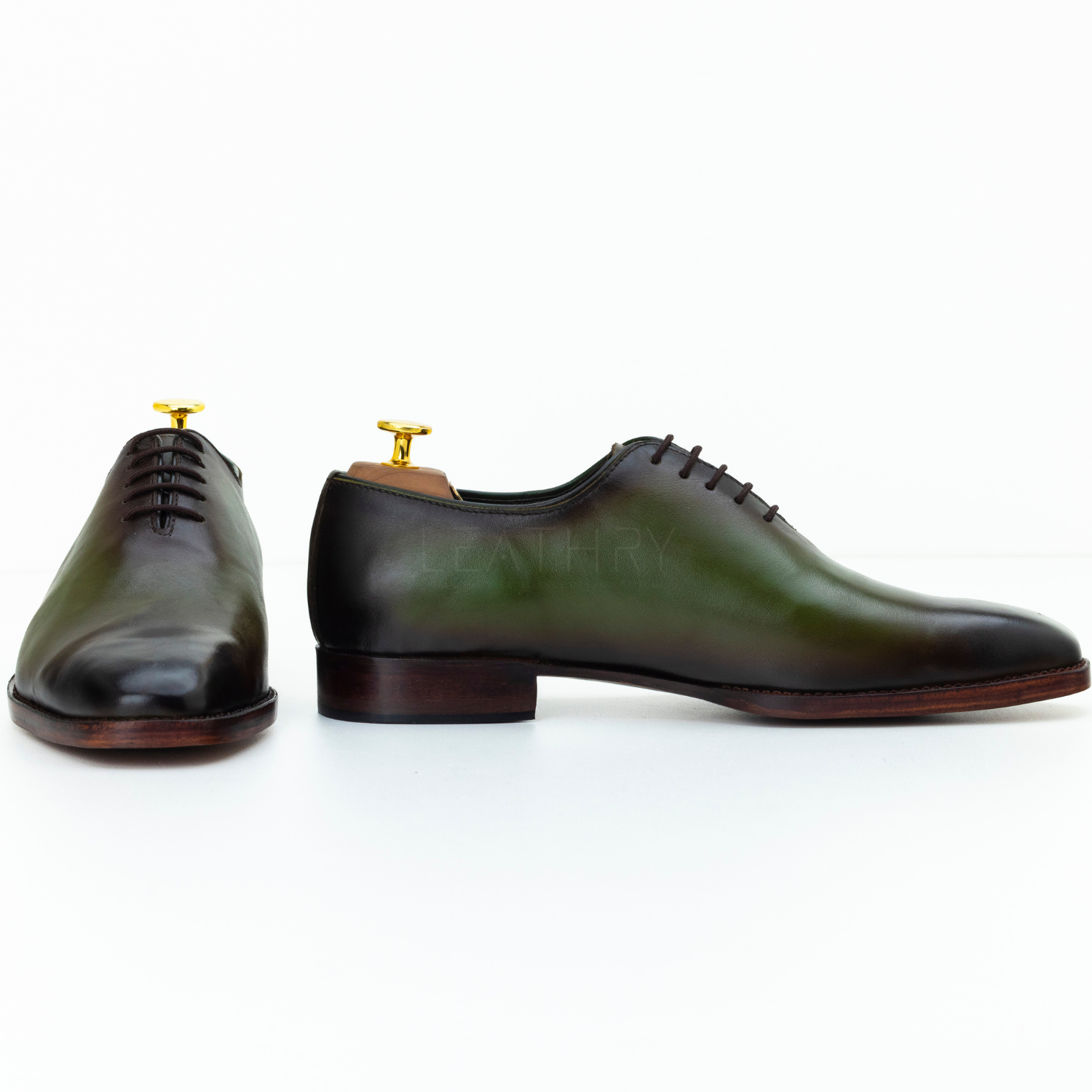 Pair of green leather dress shoes on a white background