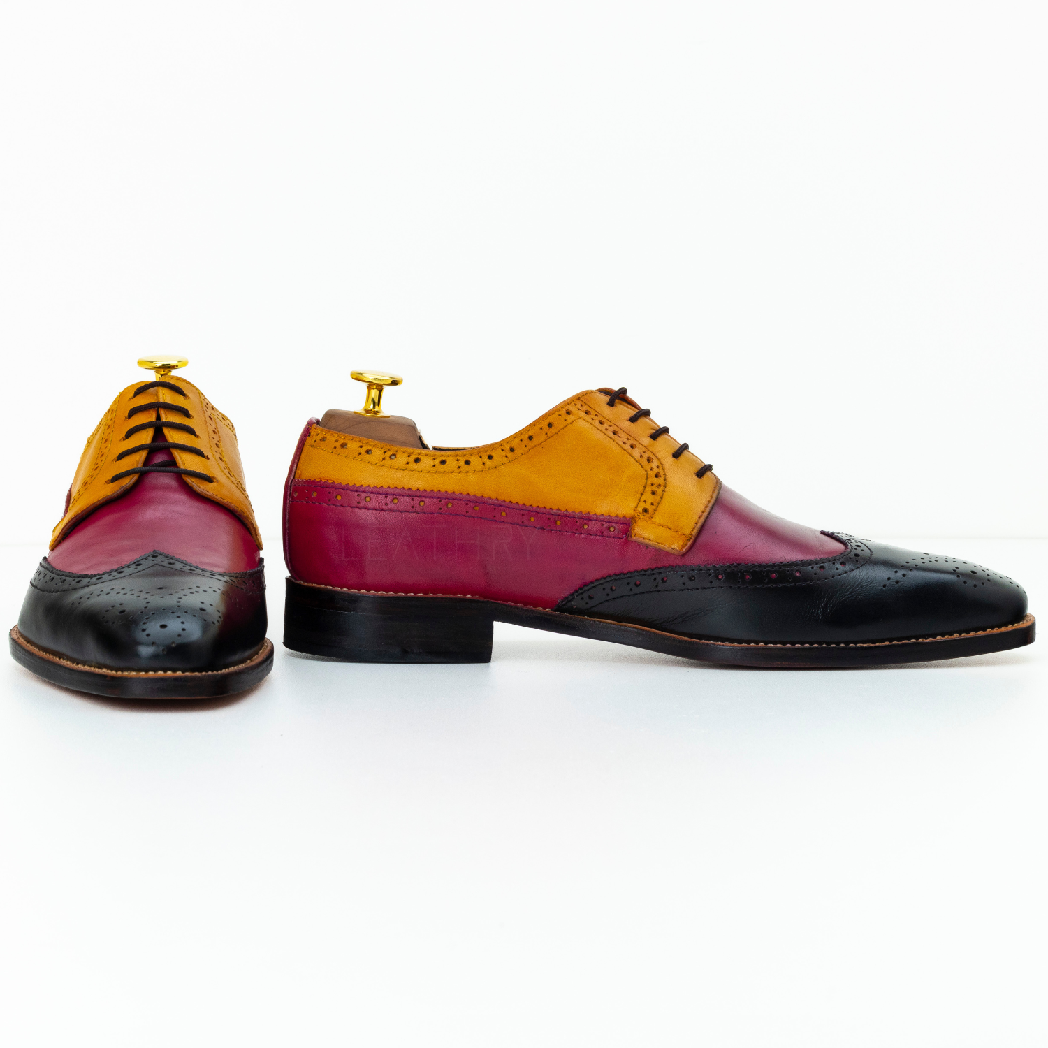 Colorful dress shoes with a mix of red, yellow, and black on a white background