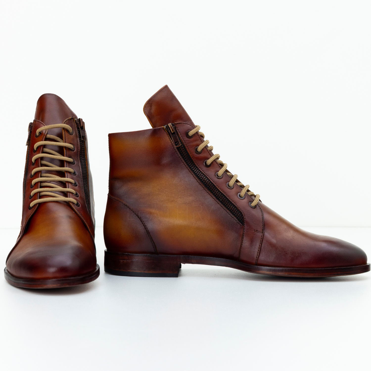 Pair of brown leather boots with laces on a white background