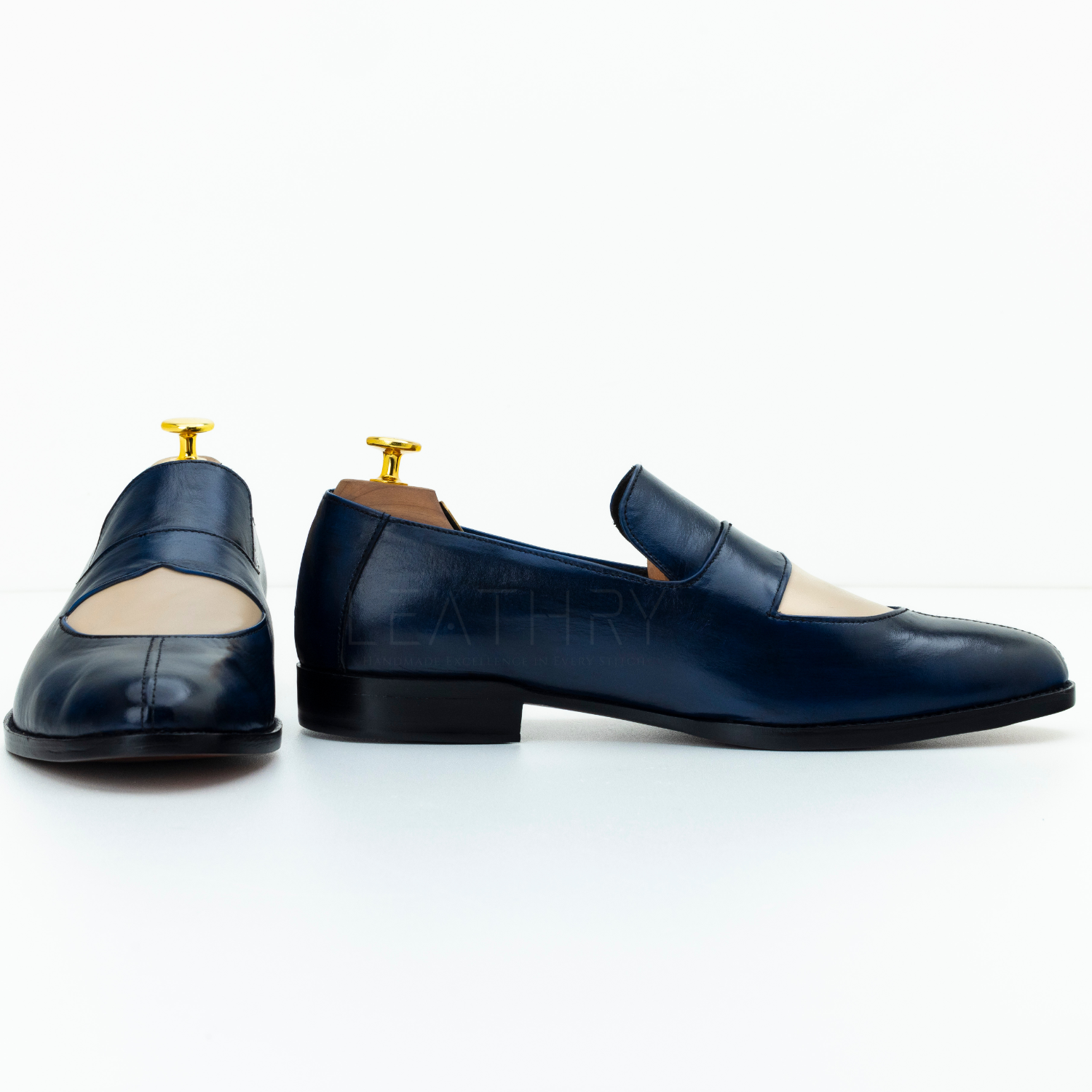 Pair of navy blue leather loafers on a white background