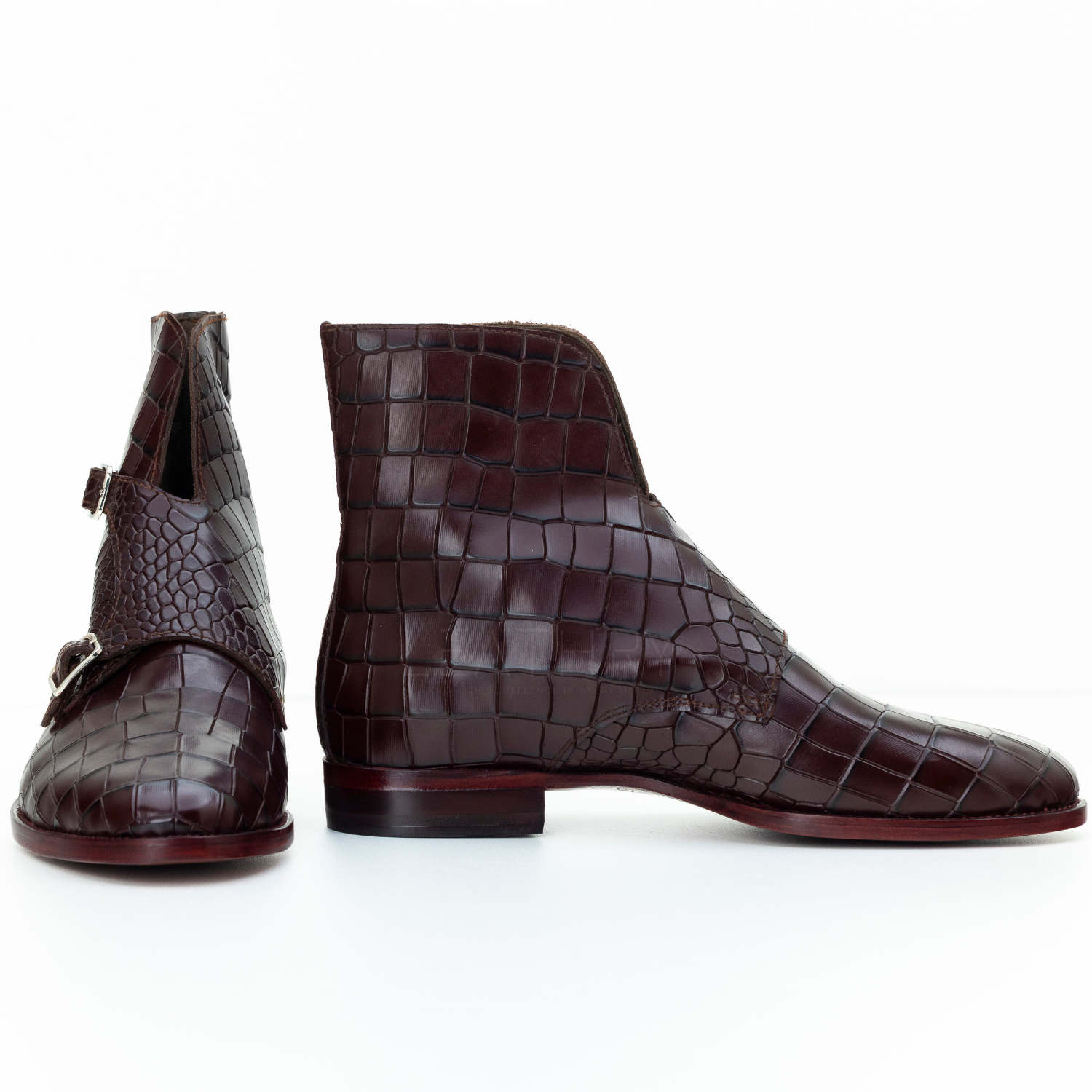 Pair of brown crocodile-patterned boots on a white background