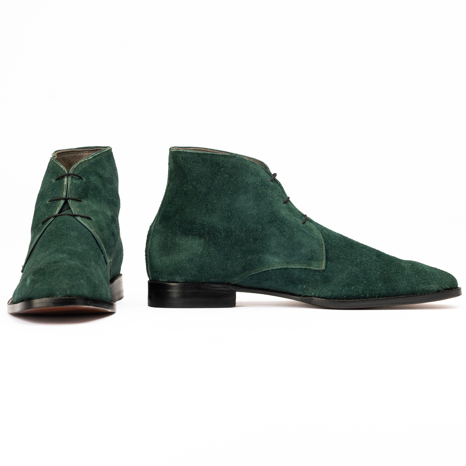Green suede boots on a white background