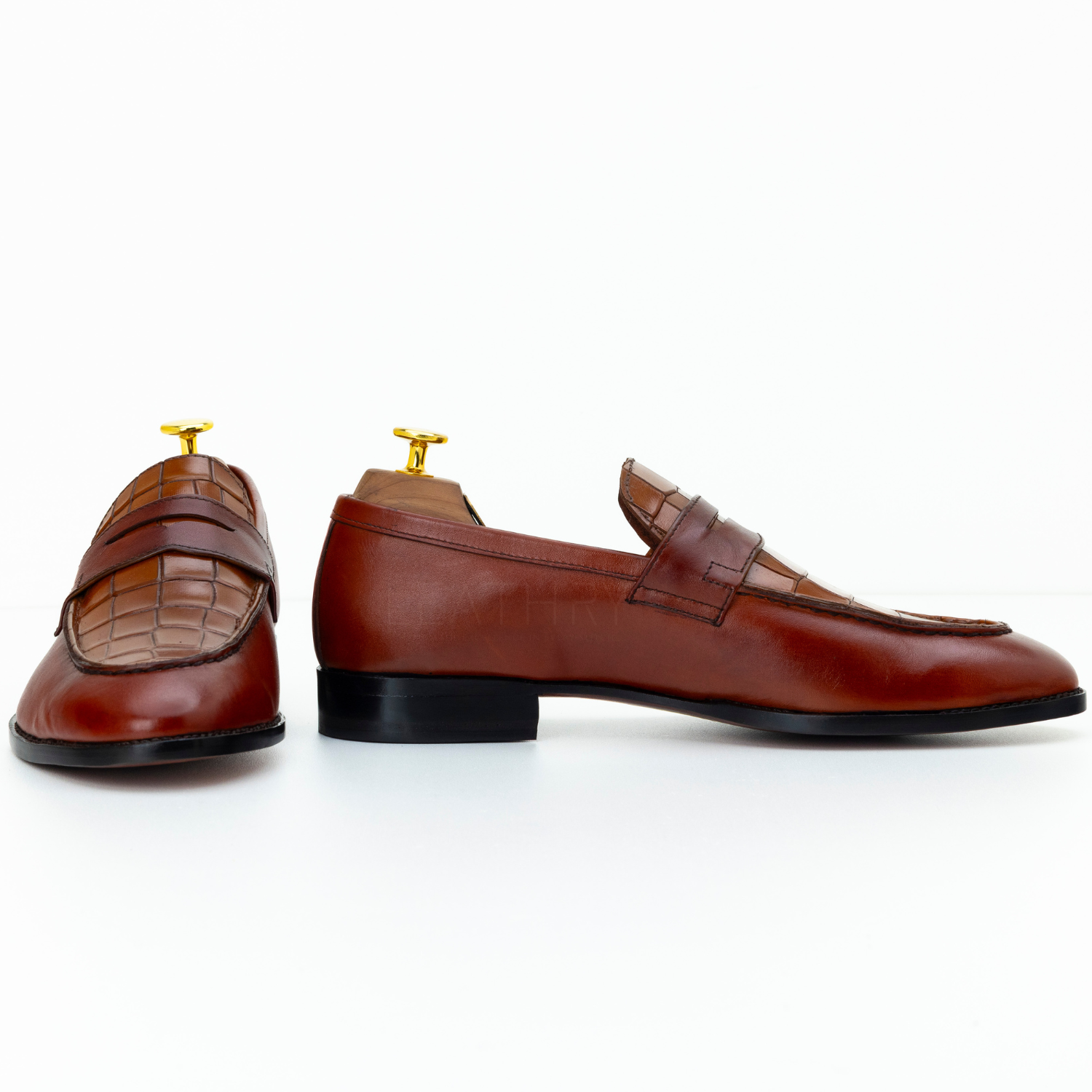Pair of brown leather loafers on a white background