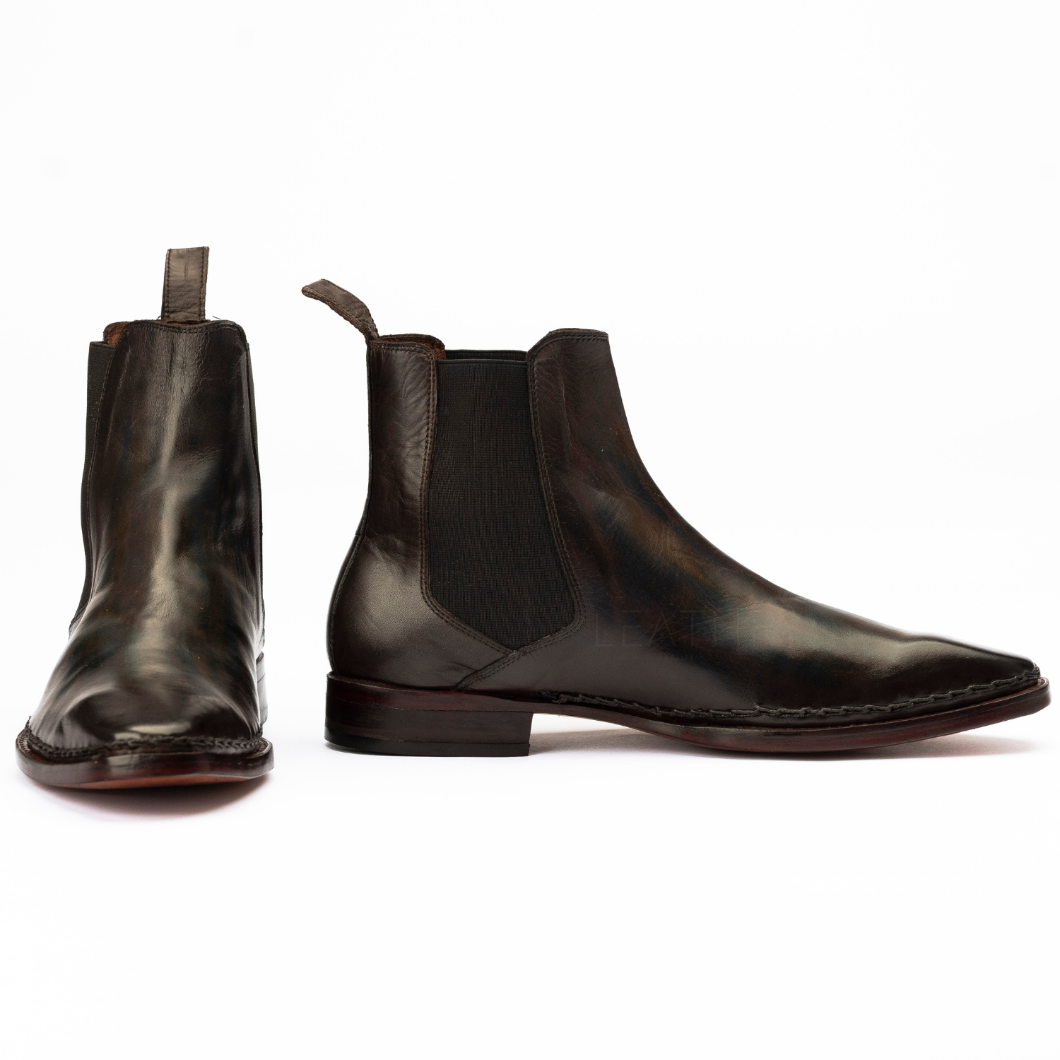 Pair of dark brown leather Chelsea boots on a white background