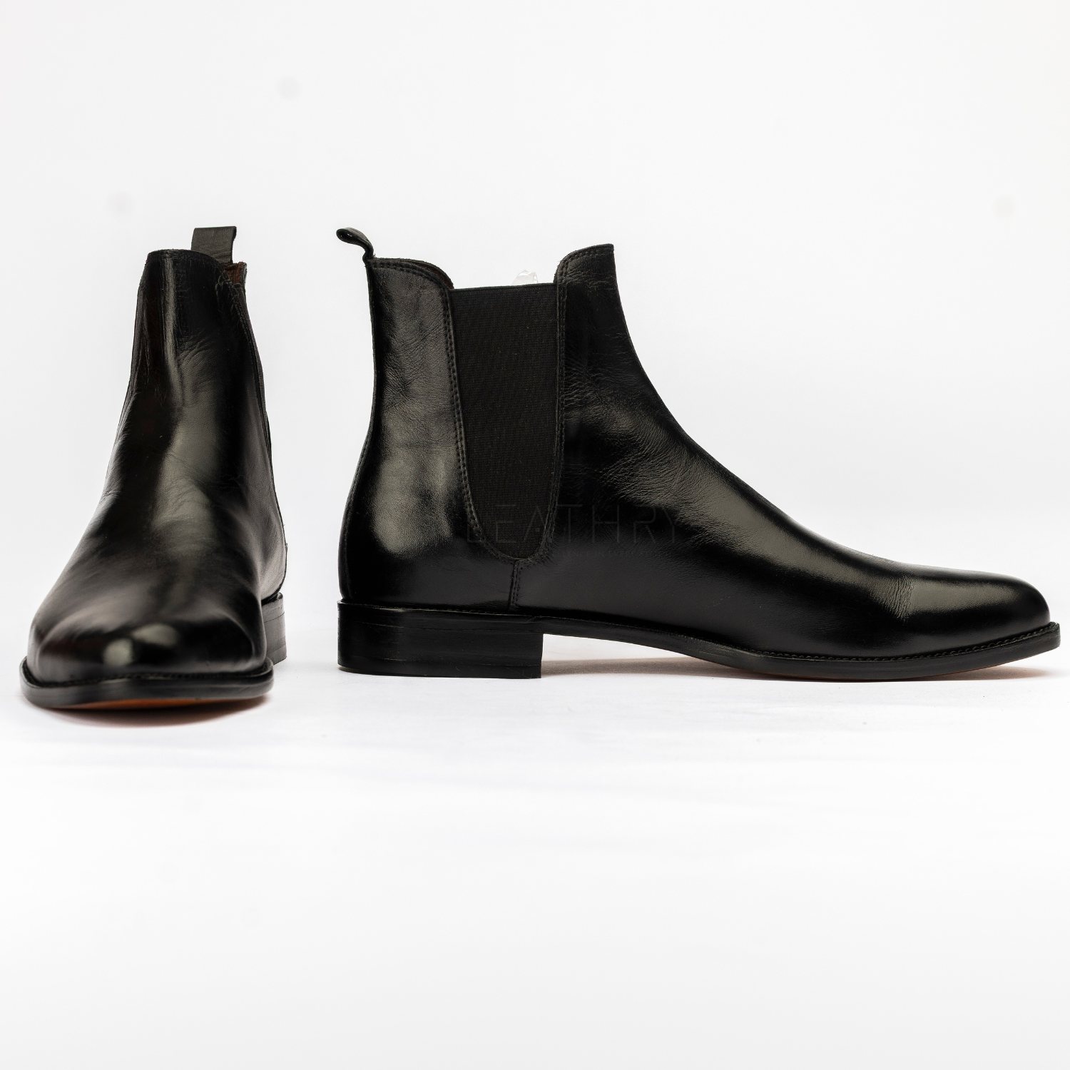 Pair of black leather Chelsea boots on a white background