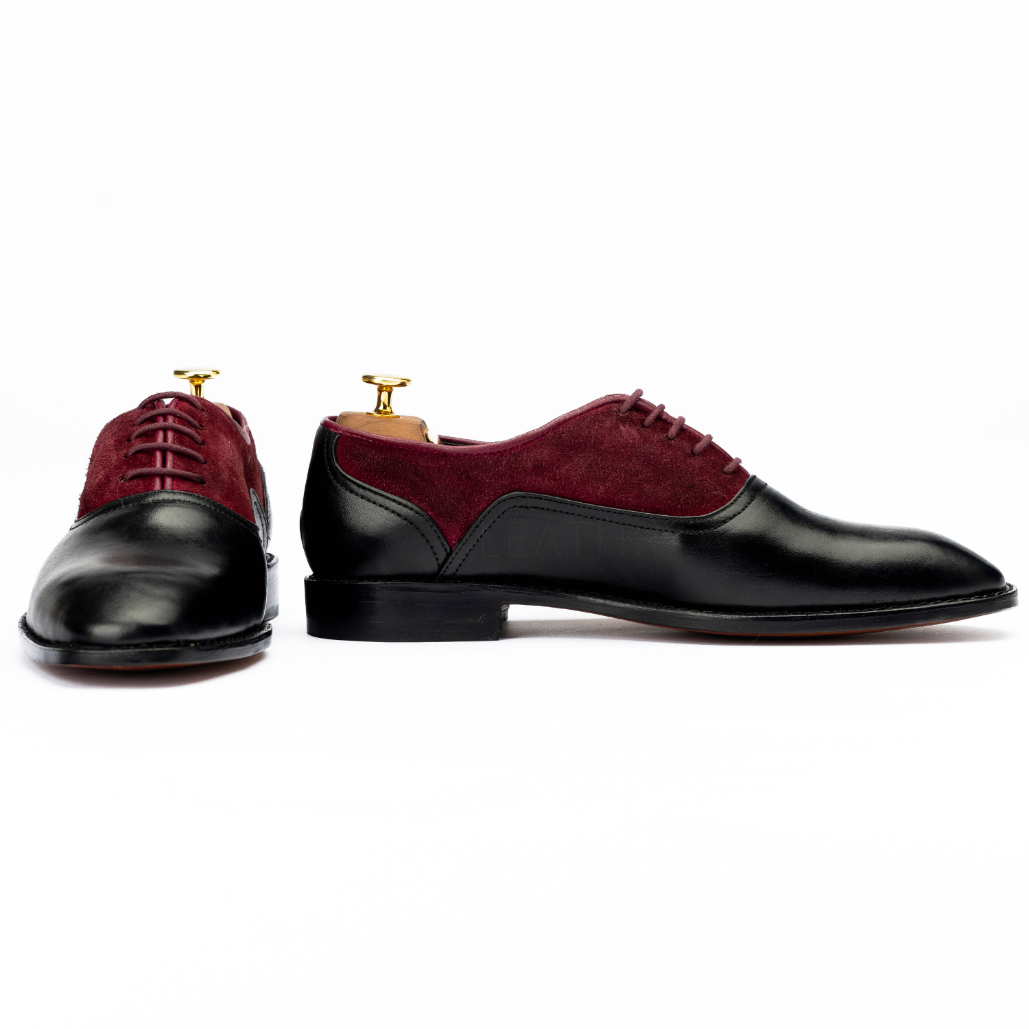 Maroon and black dress shoes on a white background