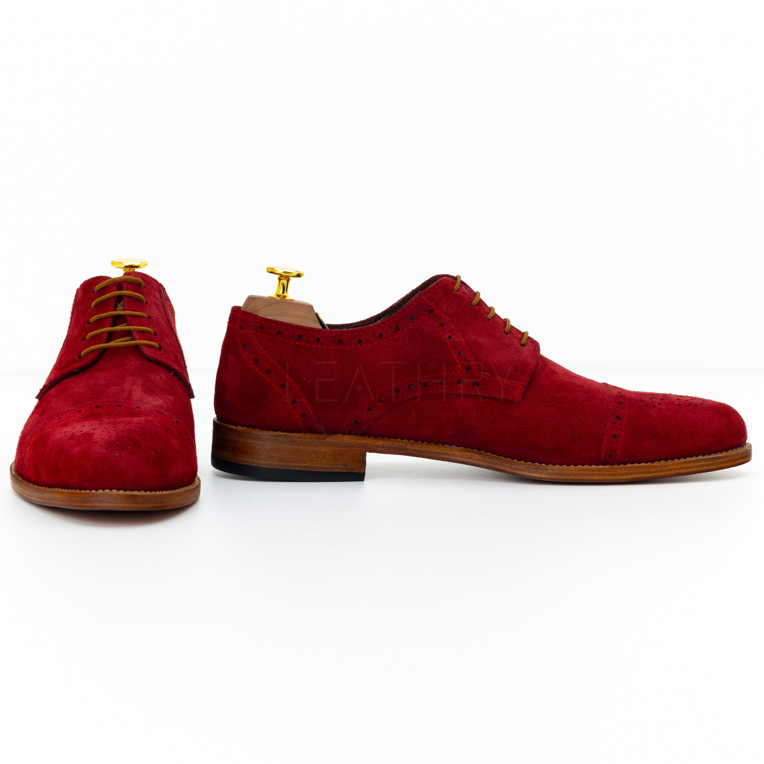 Red suede dress shoes on a white background