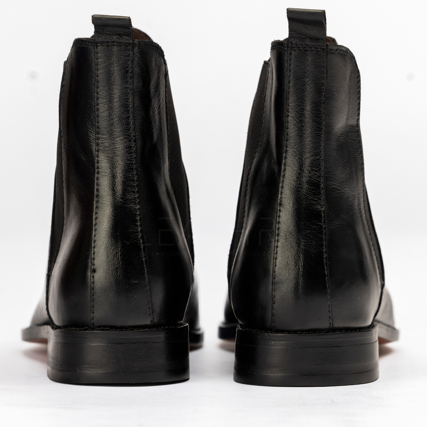 Black leather boots shown from the back on a white background