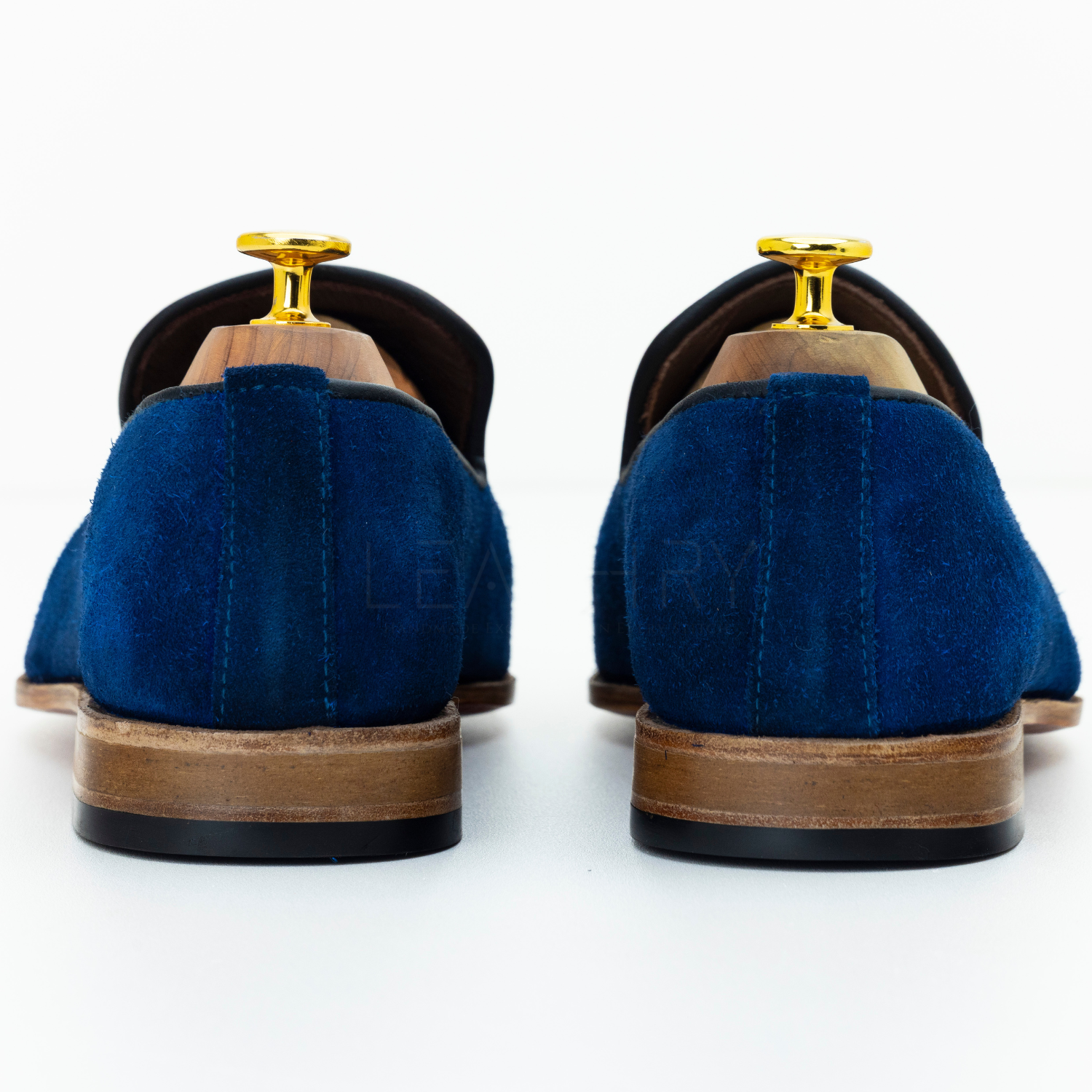 Blue suede shoes with brown soles on a white background