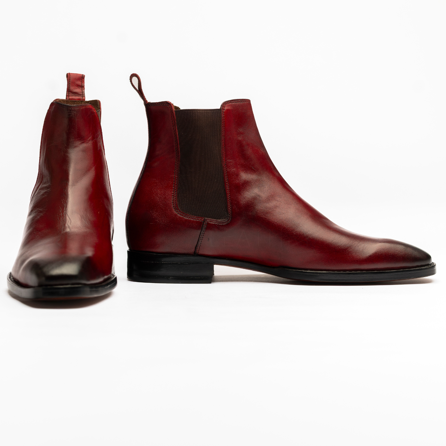 Pair of red leather boots on a white background