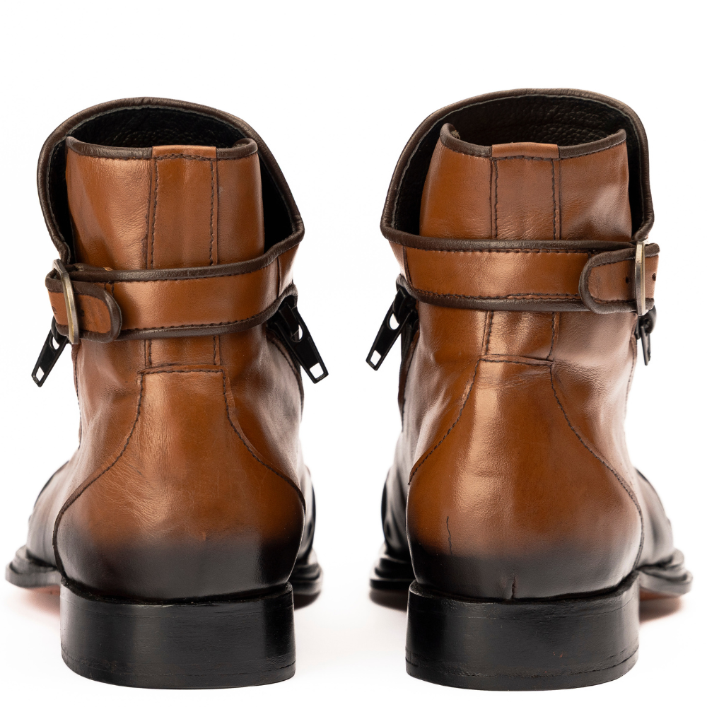Pair of brown leather boots with black soles on a white background