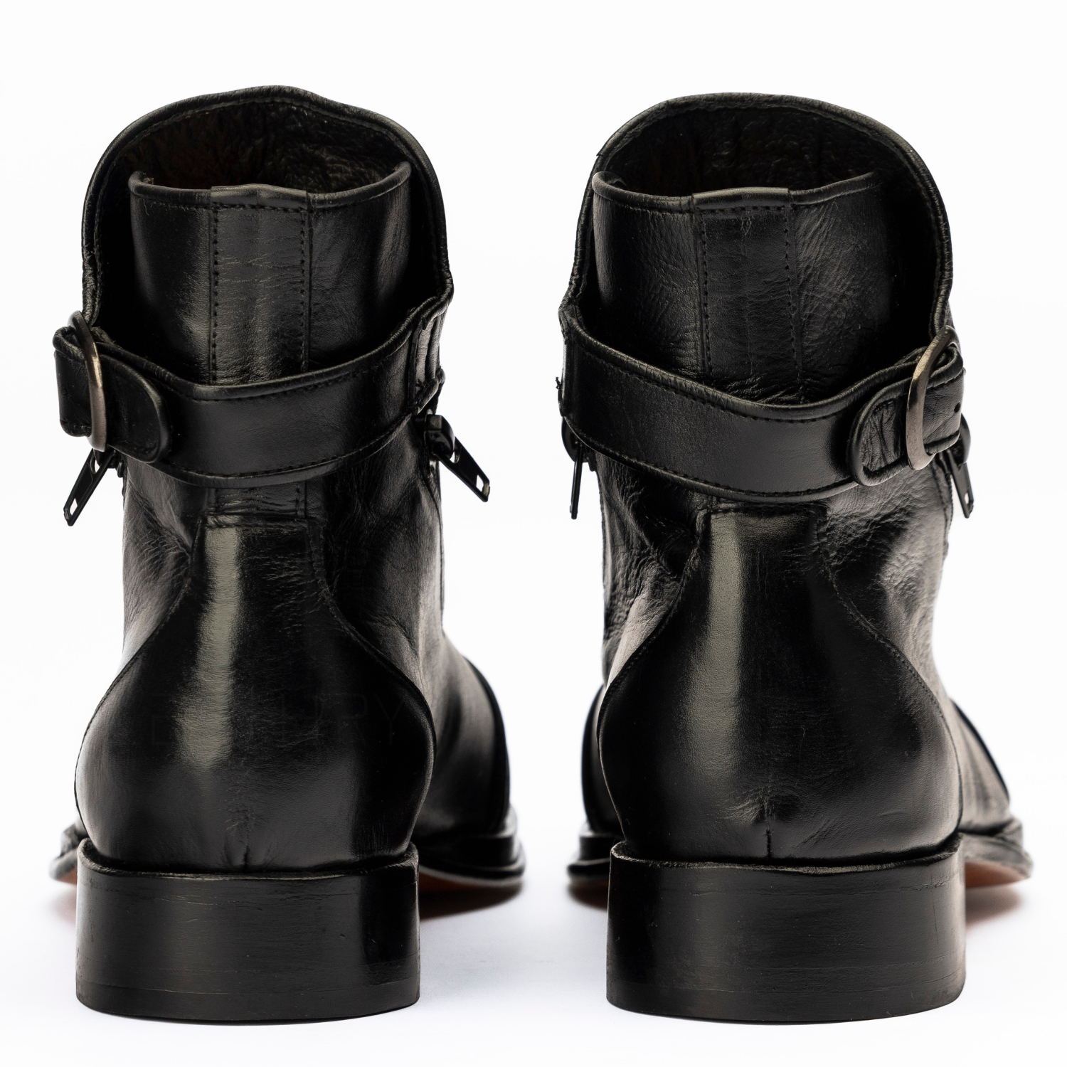 Pair of black leather boots with buckles on a white background