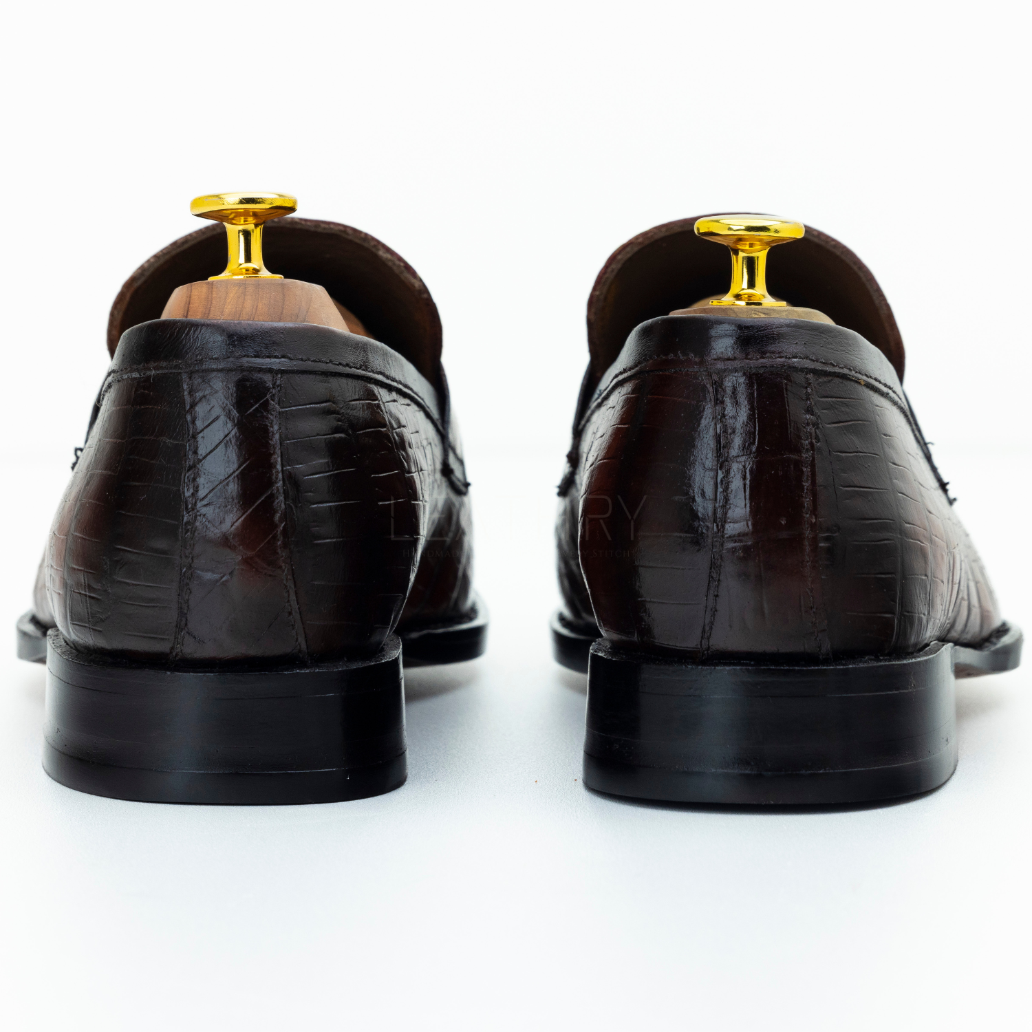 Brown dress shoes with gold tips on a white background