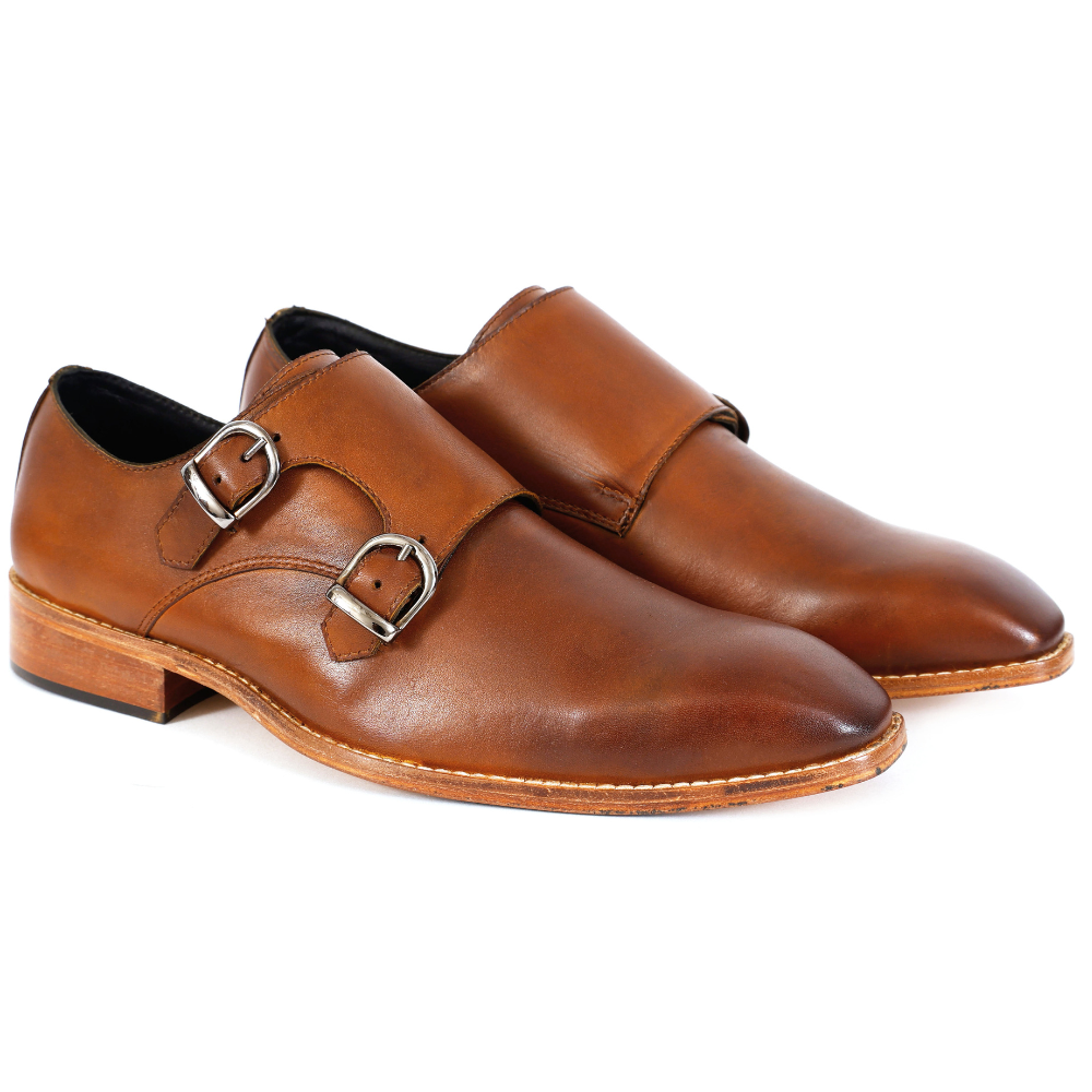 Pair of brown leather monk shoes on a white background