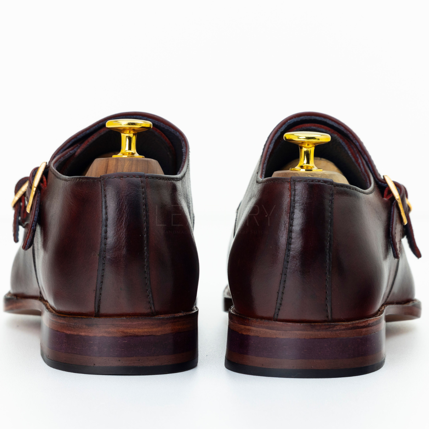 Brown leather shoes with gold buckles on a white background