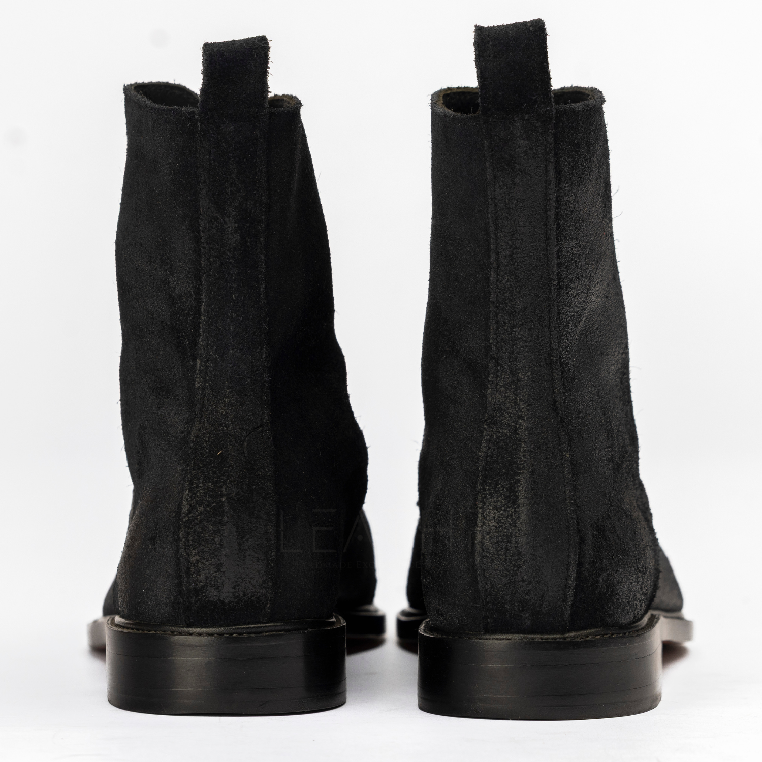 Pair of black suede boots on a white background