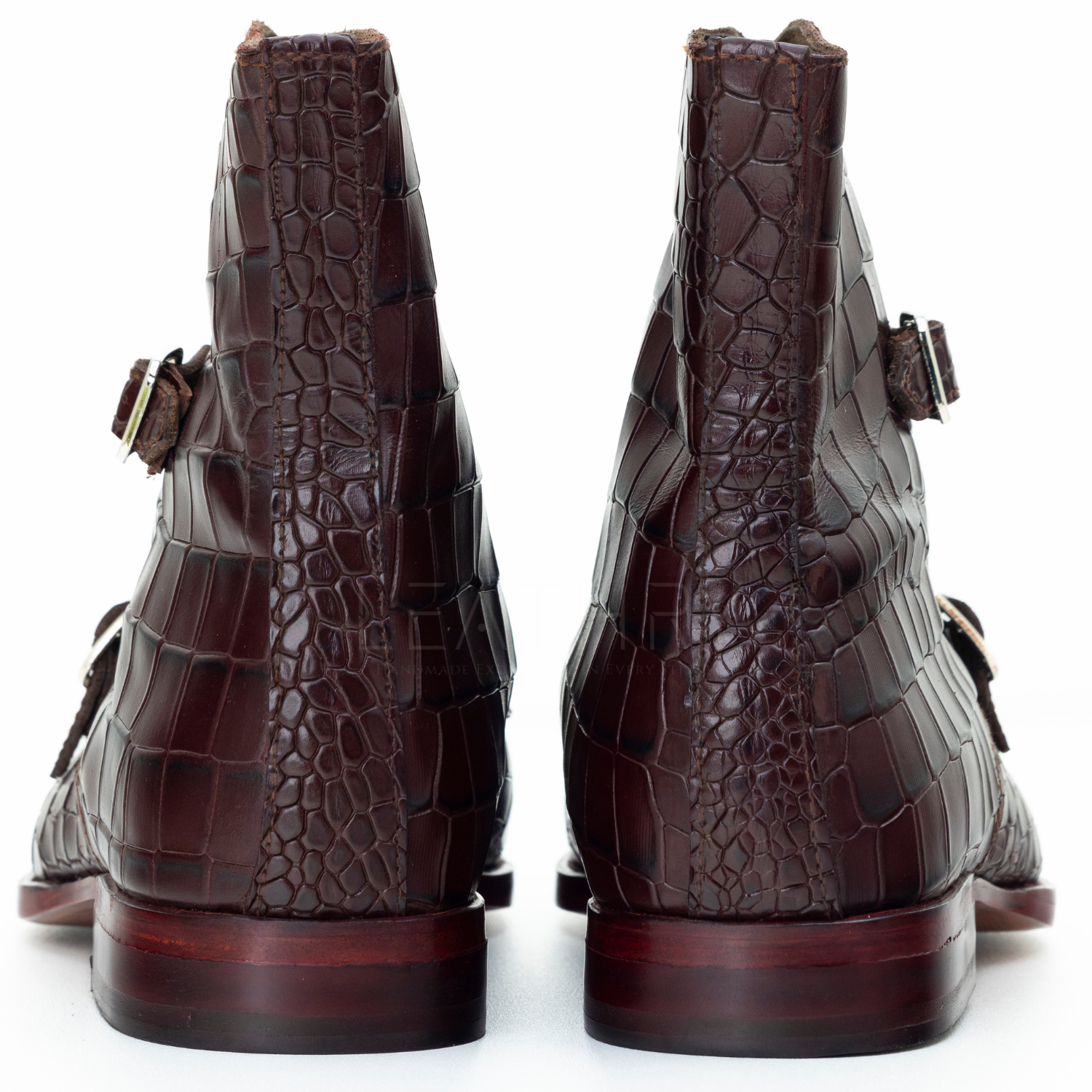 Brown crocodile-patterned boots on a white background
