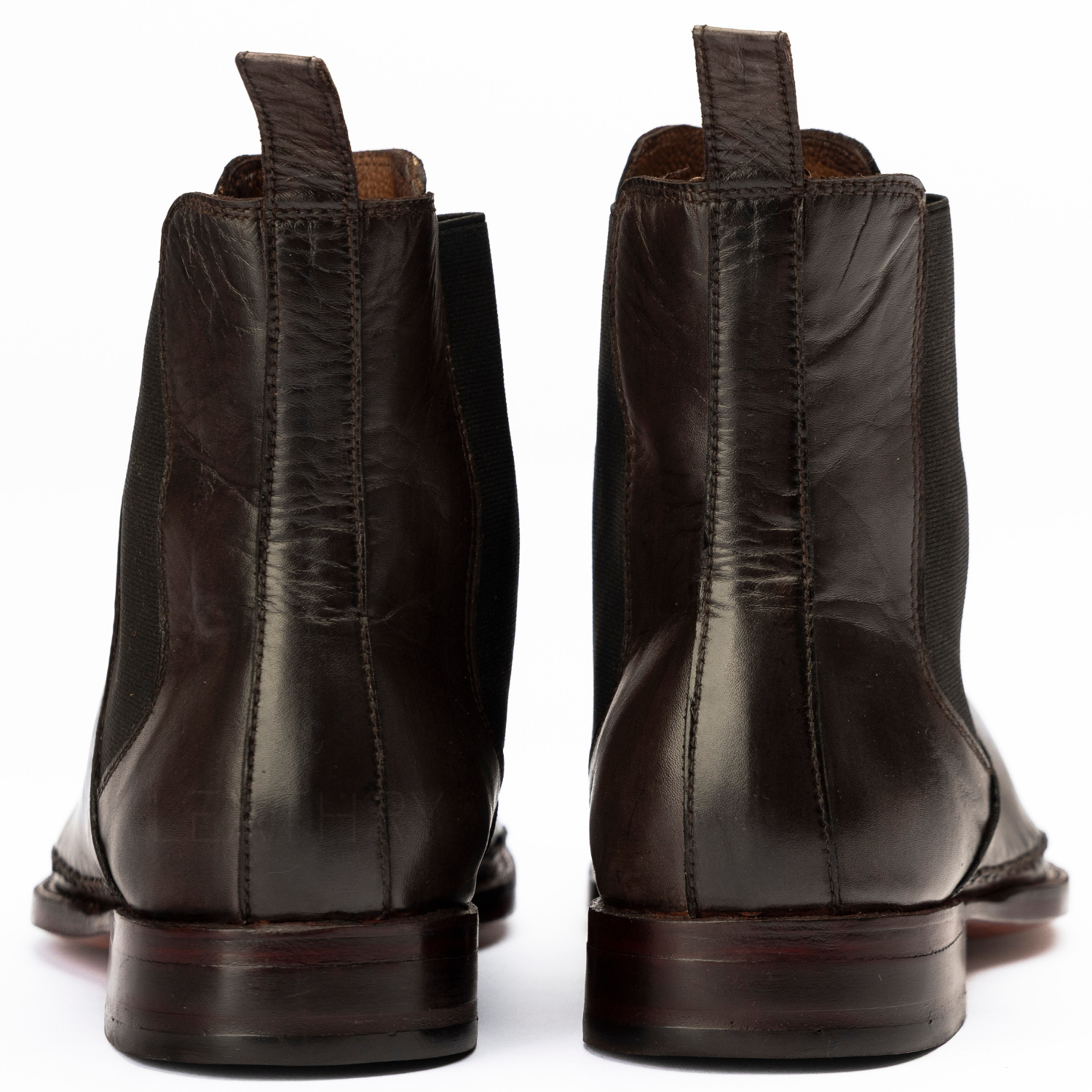 Pair of dark brown leather boots on a white background