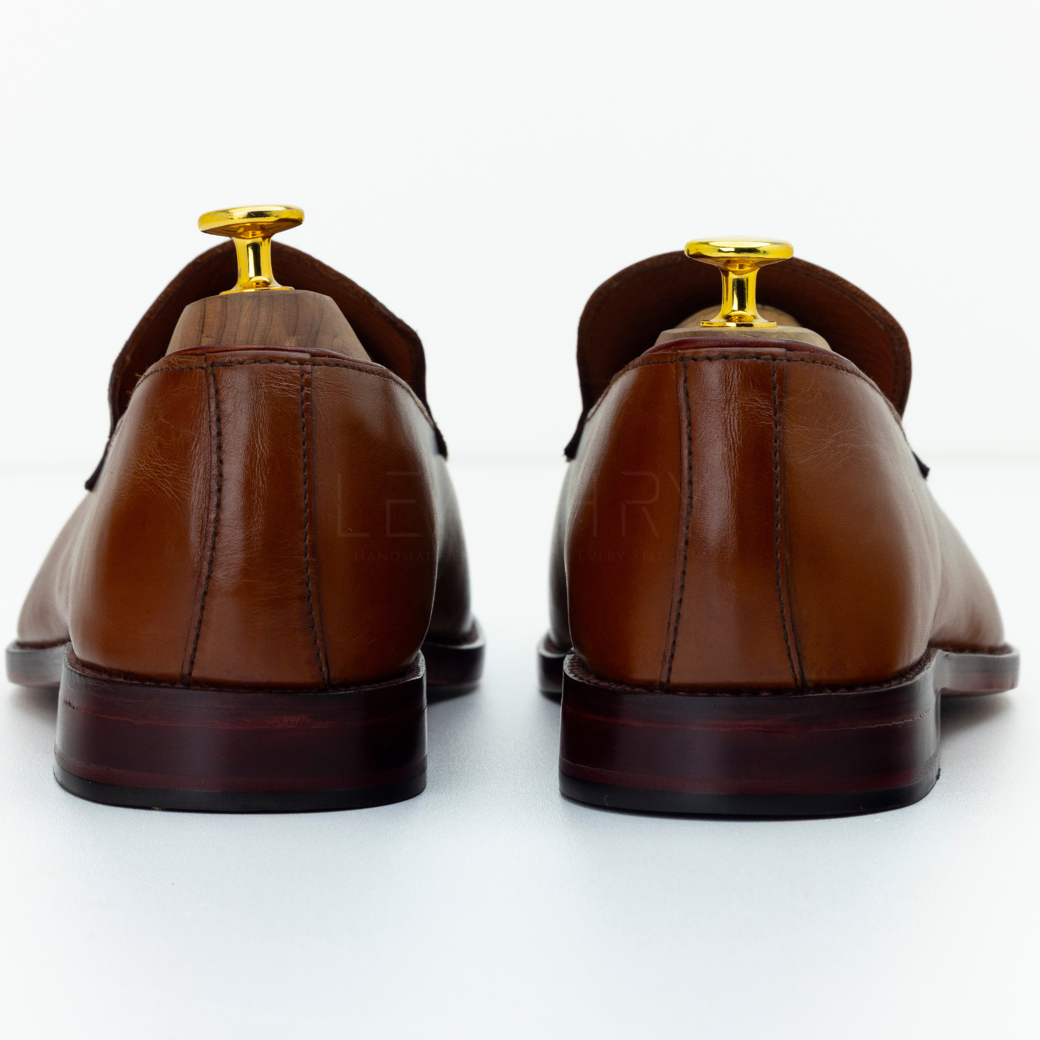 Brown leather shoes with gold buckles on a white background