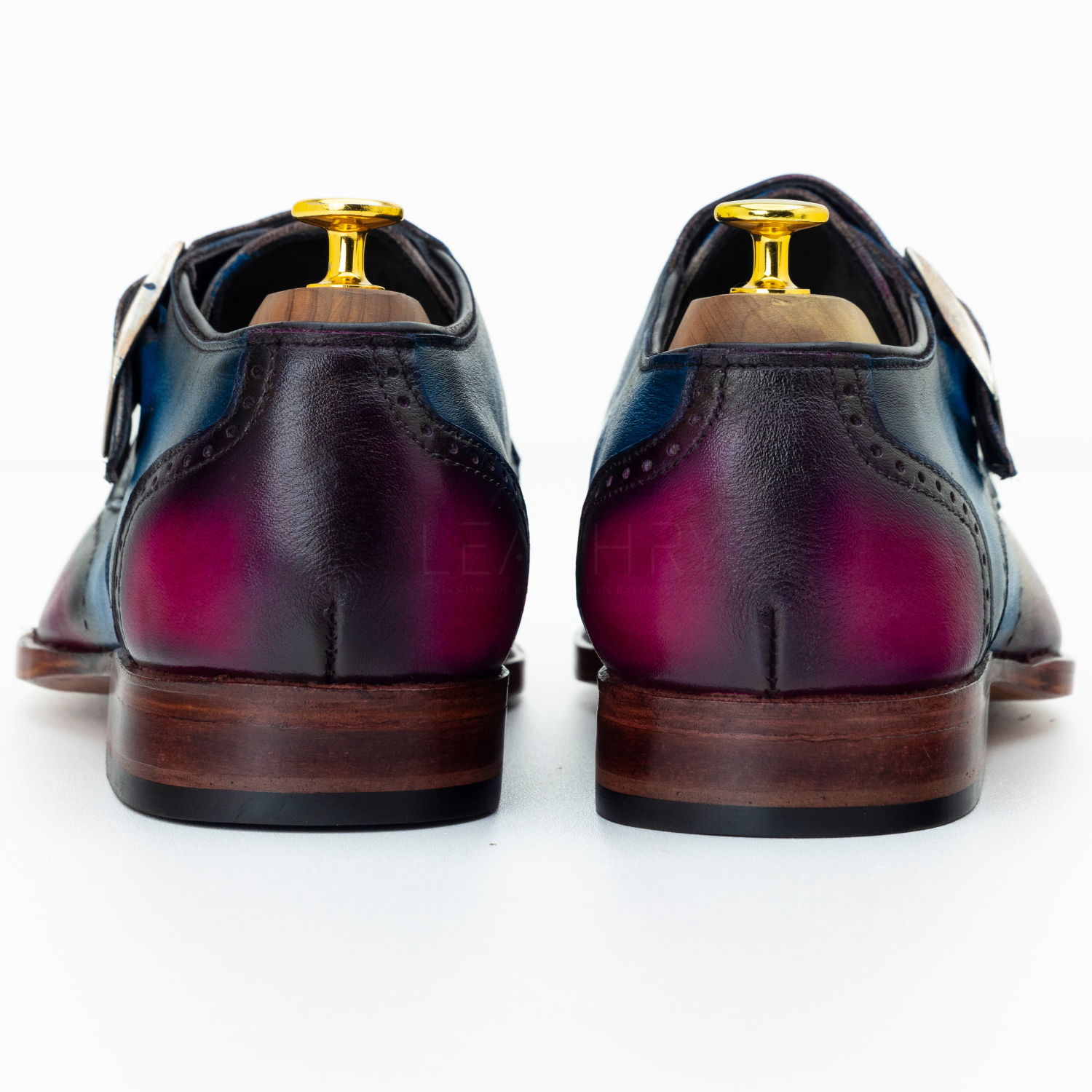Pair of polished leather shoes with a gradient color on a white background