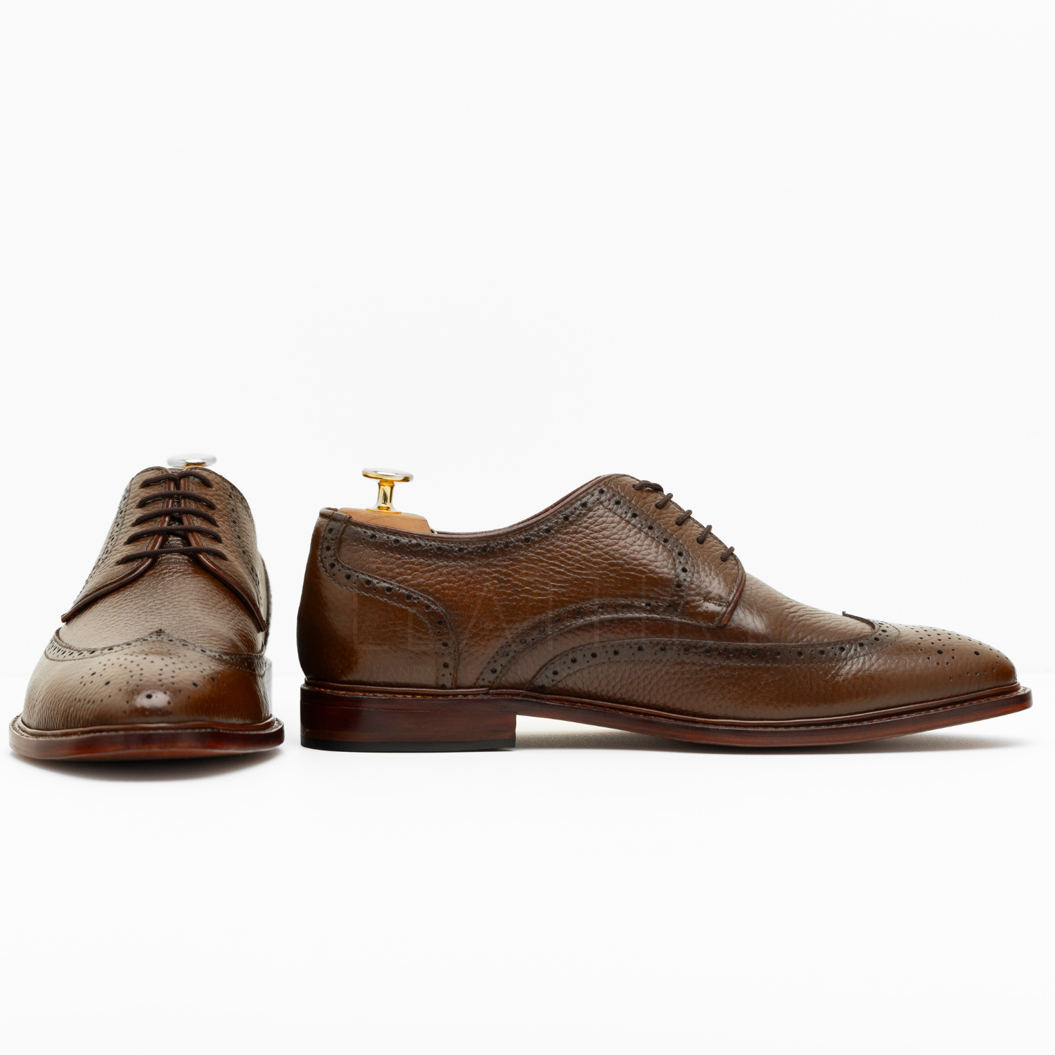 Pair of brown leather dress shoes on a white background