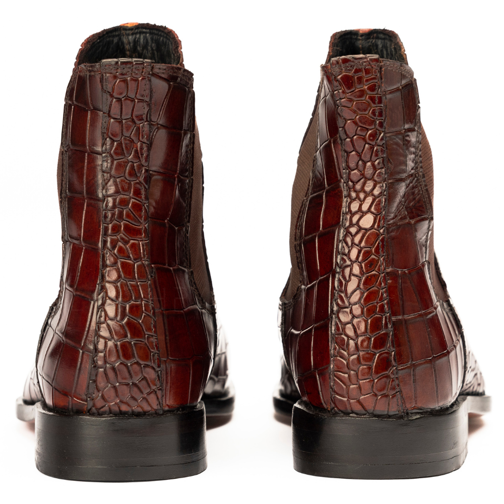Brown crocodile-patterned boots on a white background