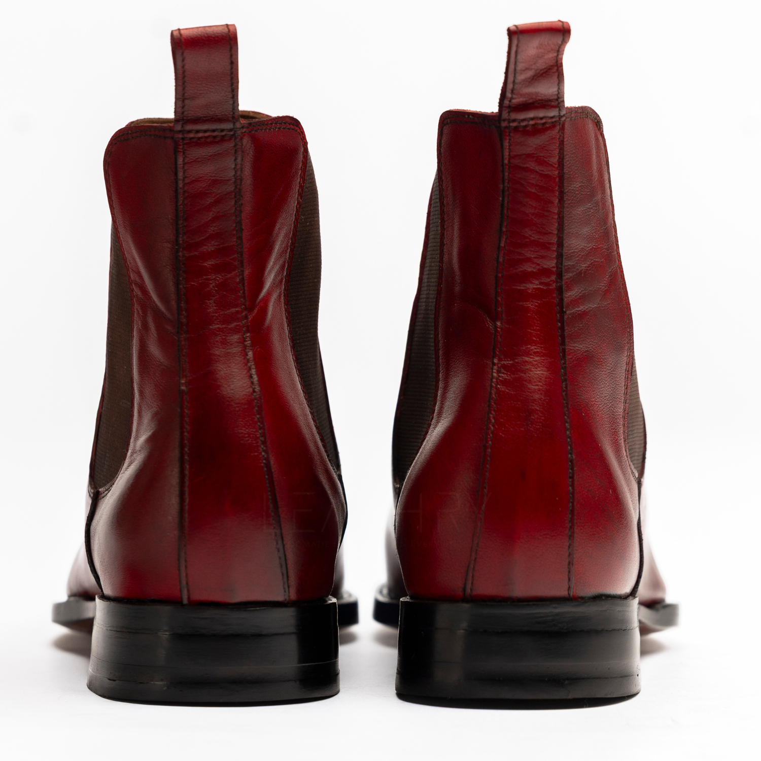 Pair of red leather boots shown from the back on a white background