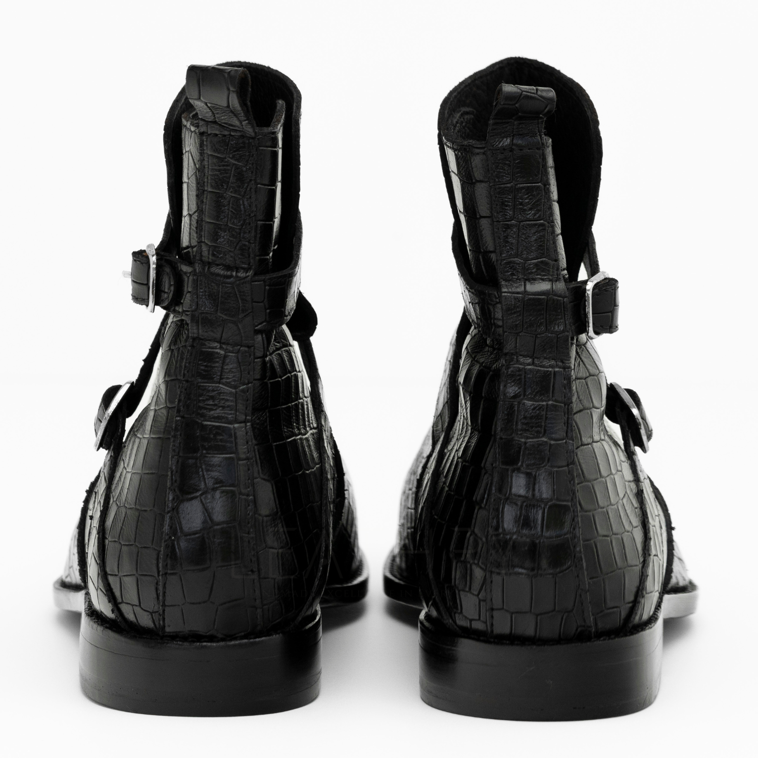 Black crocodile-patterned boots on a white background