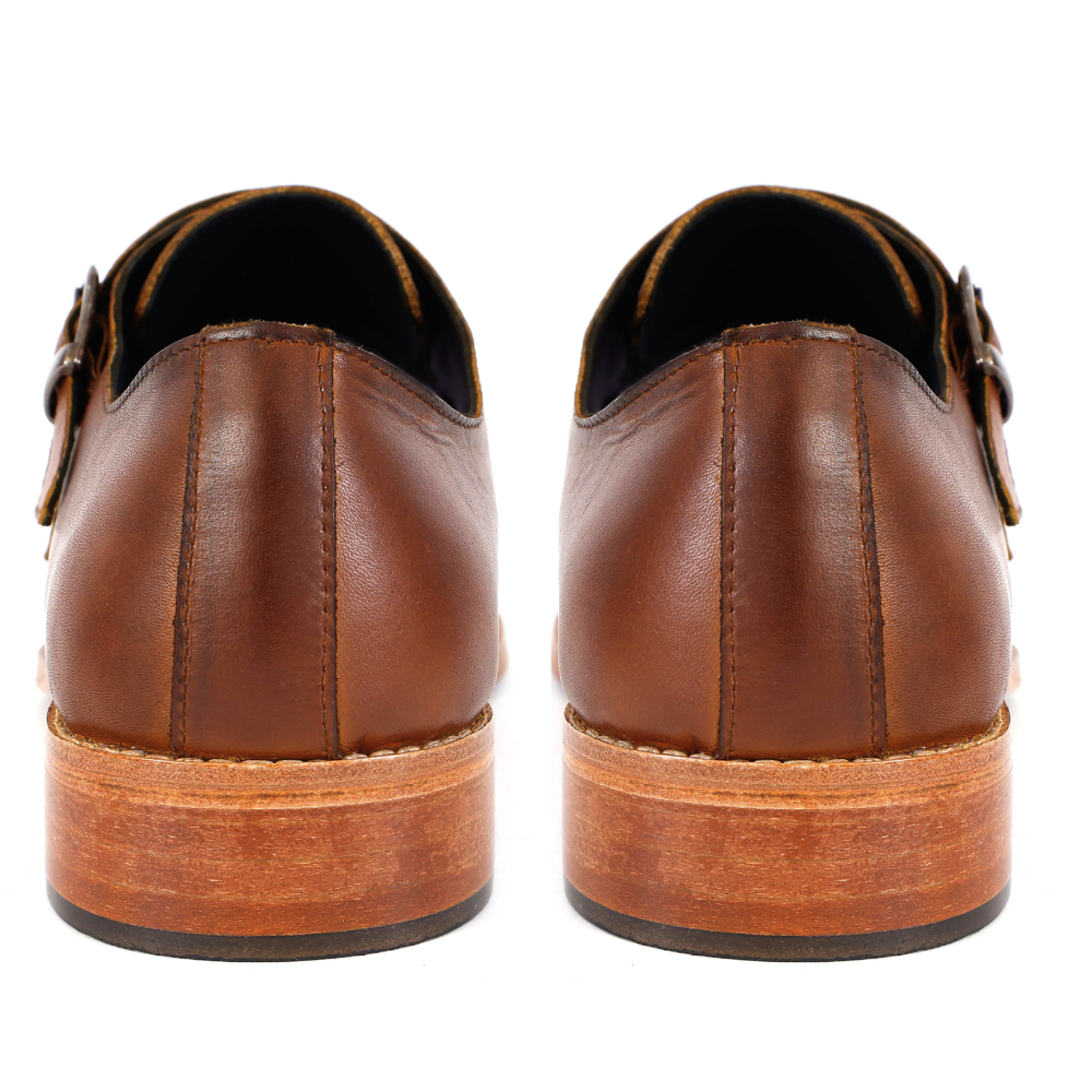 Pair of brown leather shoes with buckles on a white background