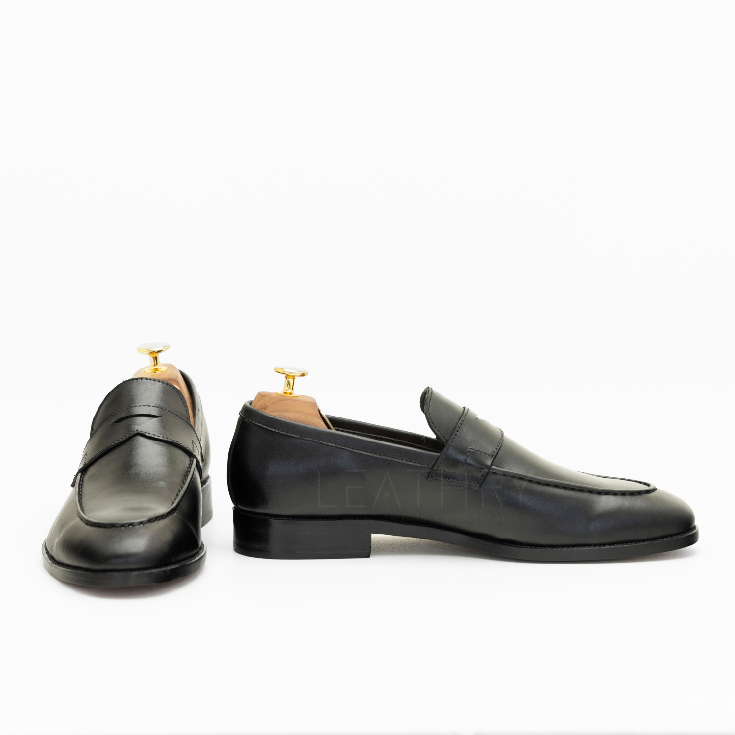 Pair of black loafers on a white background