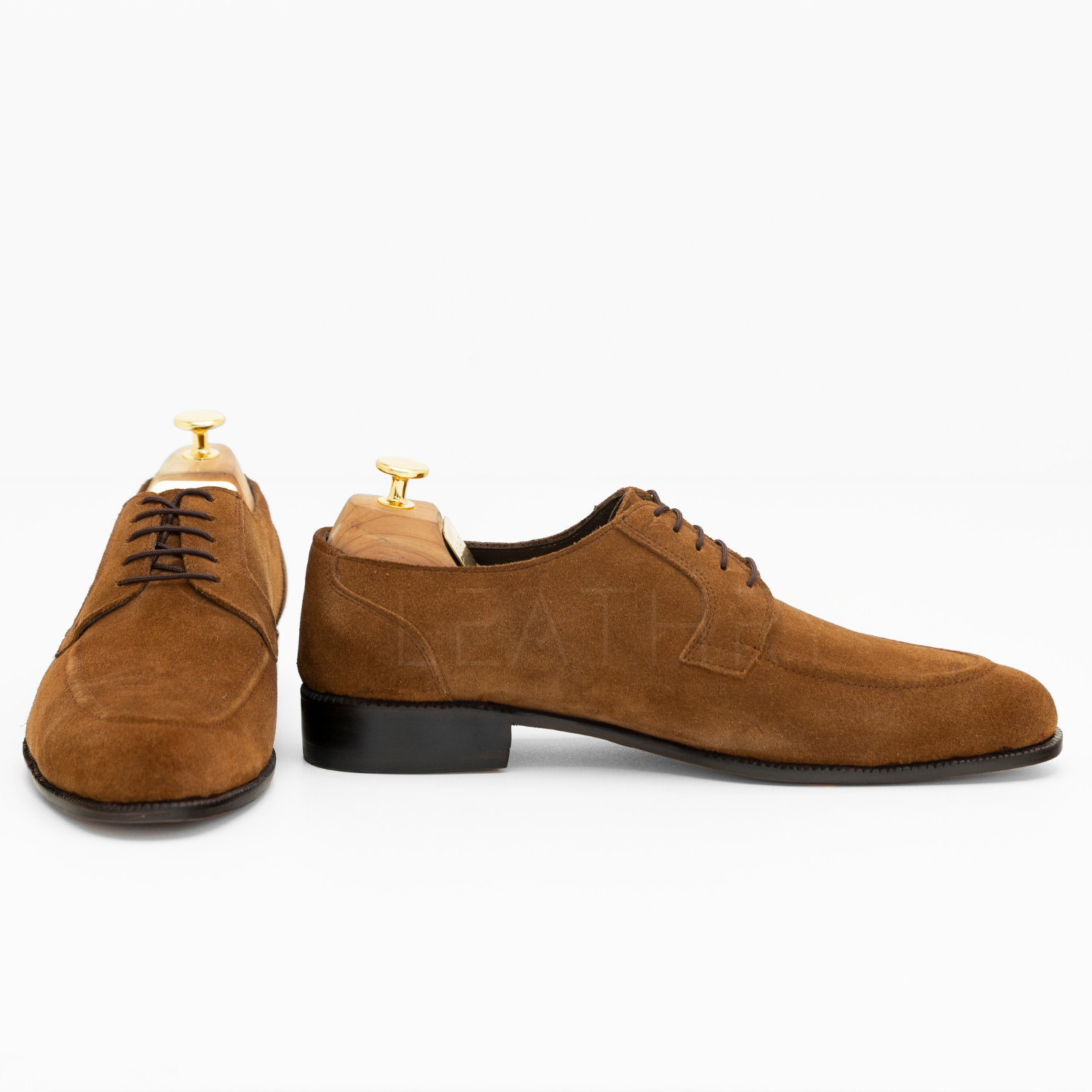 Brown suede dress shoes on a white background