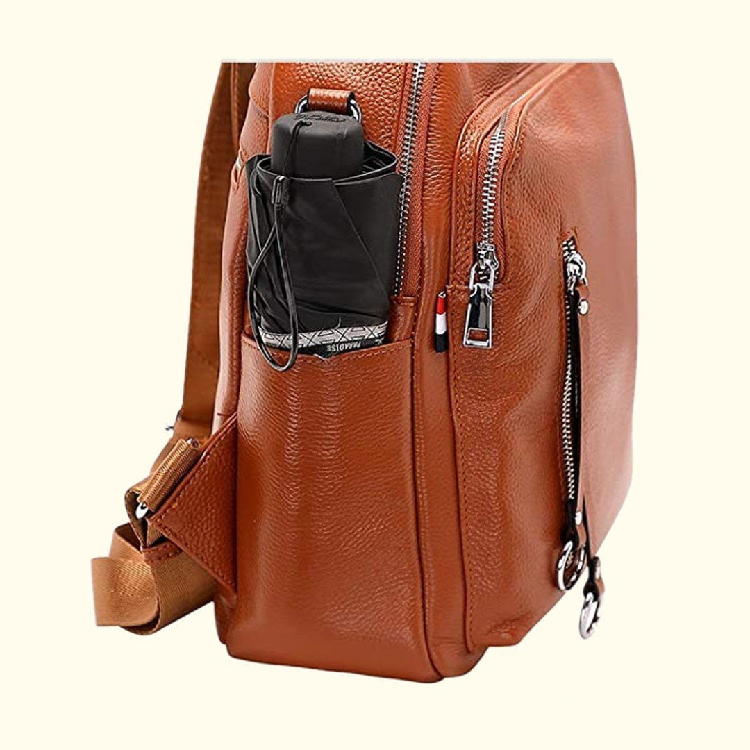 Brown leather backpack with a black water bottle holder on a white background