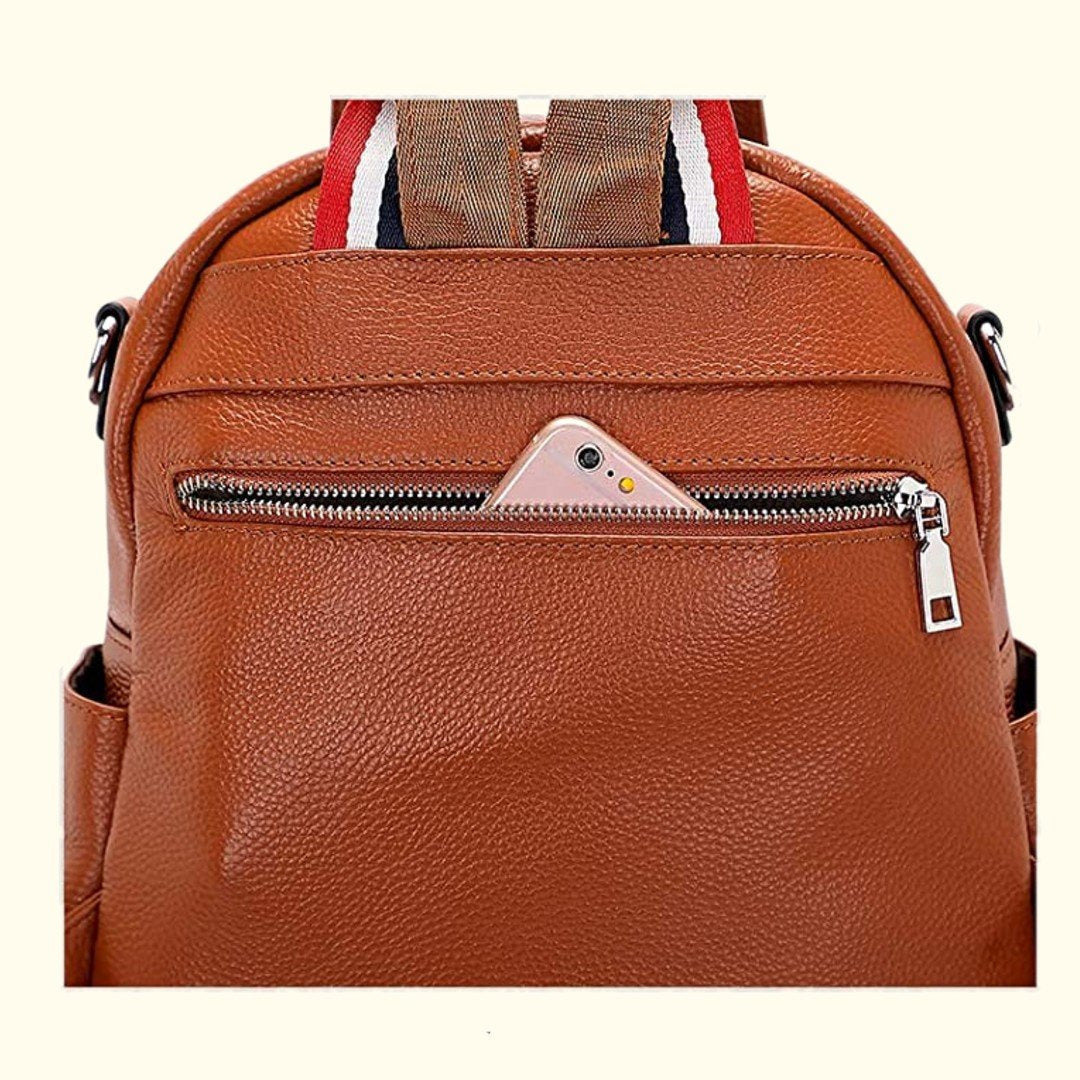 Brown leather backpack with a phone in a front pocket on a white background
