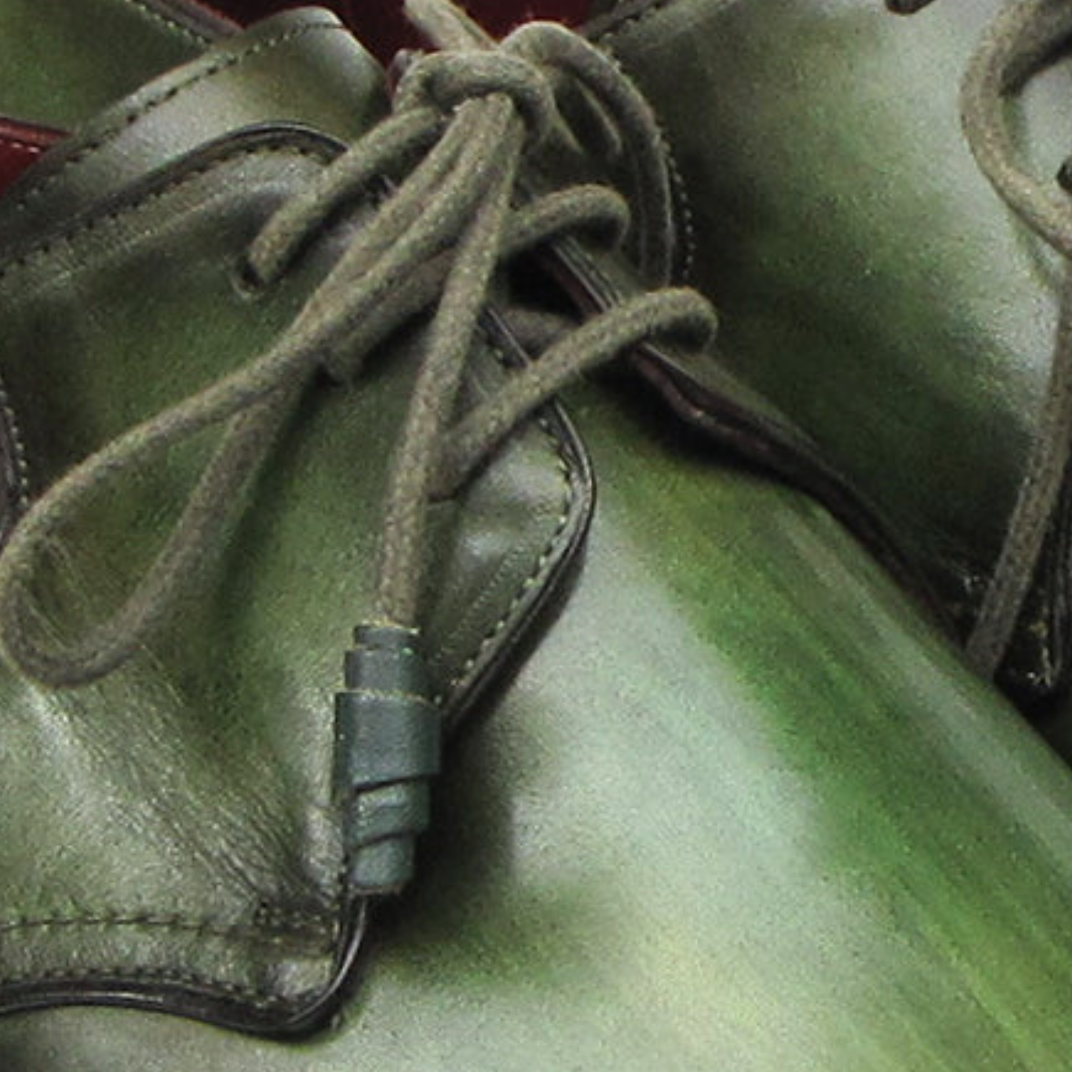 Close-up of green leather shoes with laces