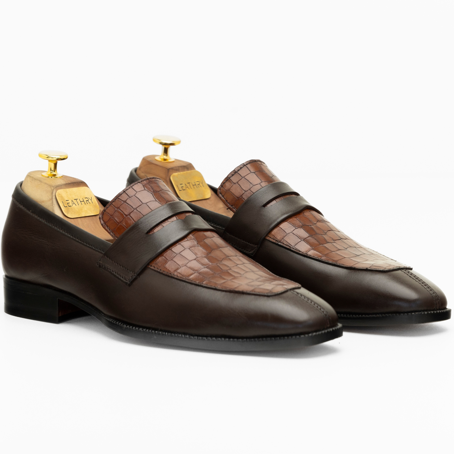 Pair of brown leather loafers with a textured pattern on a white background