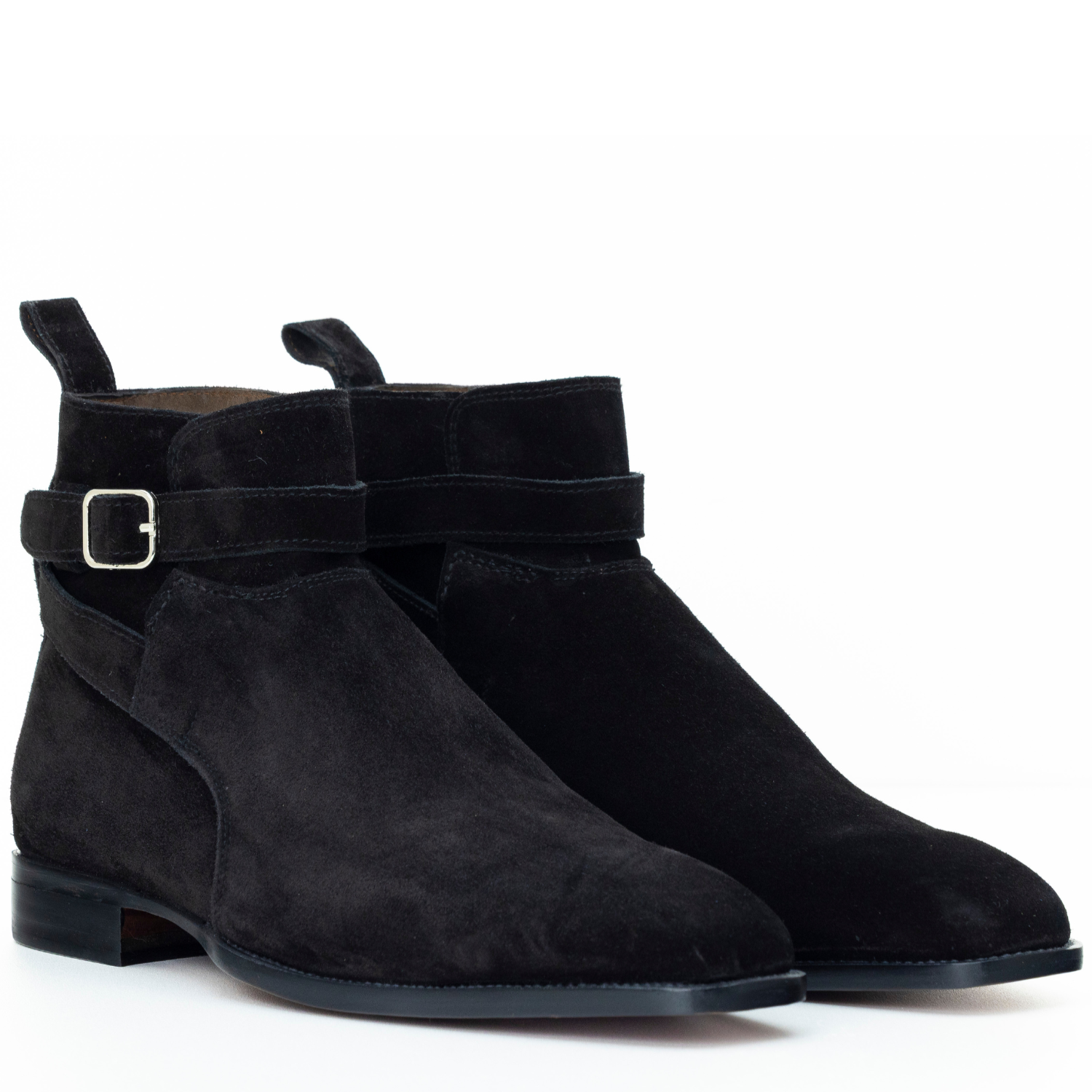 Pair of black suede ankle boots with a strap and buckle on a white background